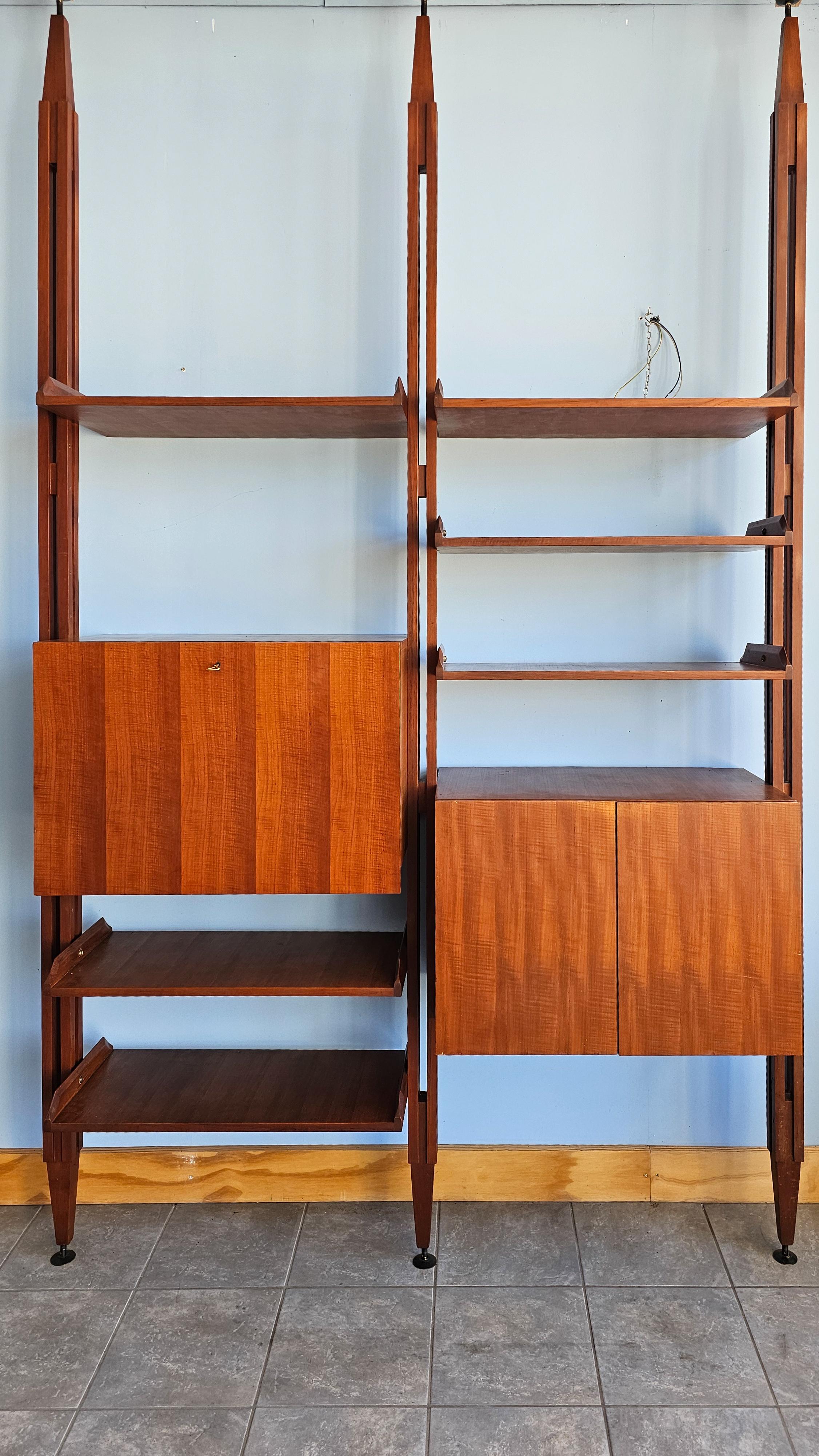 The iconic ceiling-mounted bookcase model 'LB7', designed by the renowned designer Franco Albini around 1960, represents a unique example of refined and functional design. This innovative structure features two bays with solid teak wood uprights