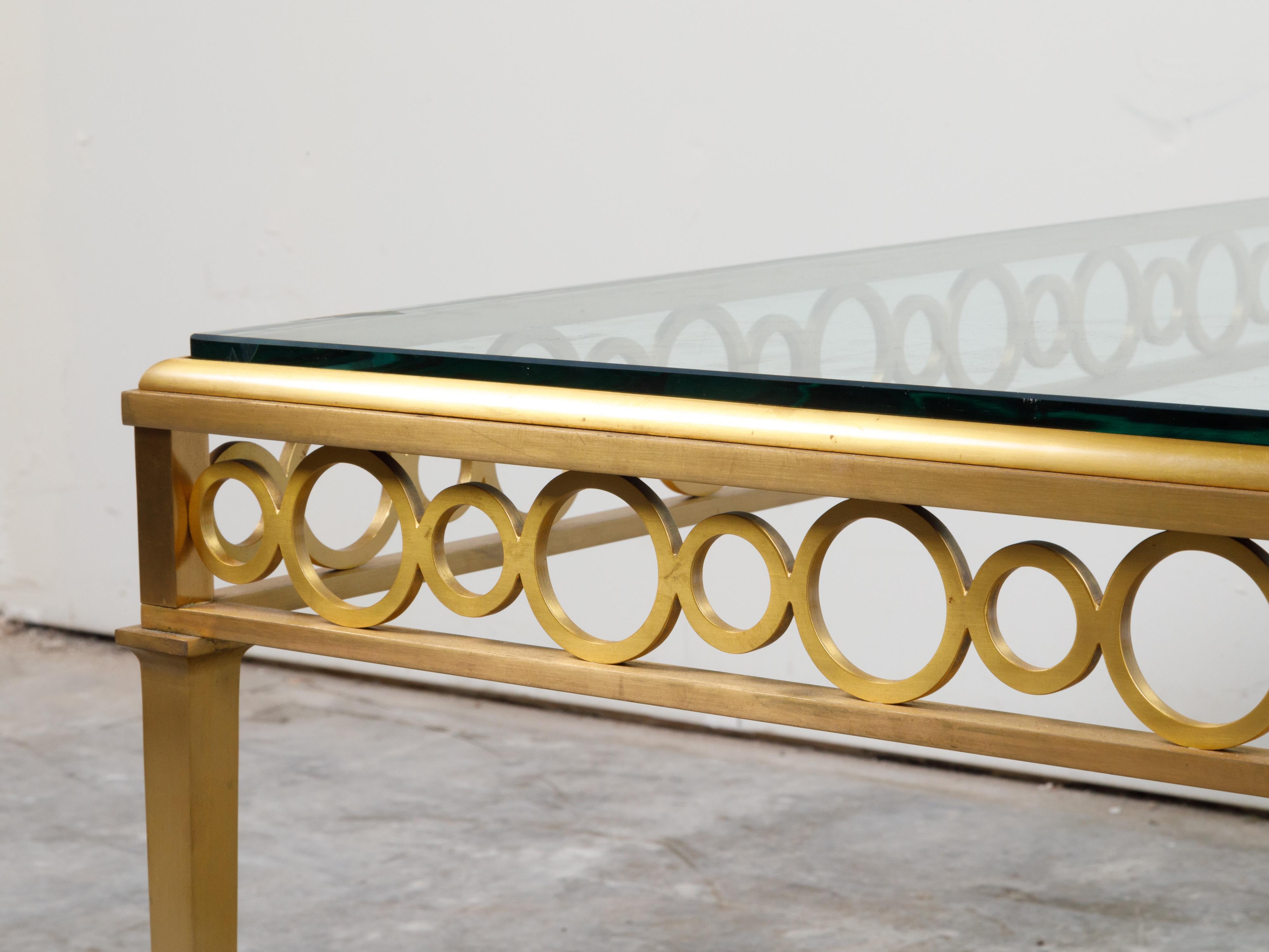 20ième siècle Table basse italienne du milieu du siècle dernier en bronze doré avec plateau en verre et motifs en anneau en vente
