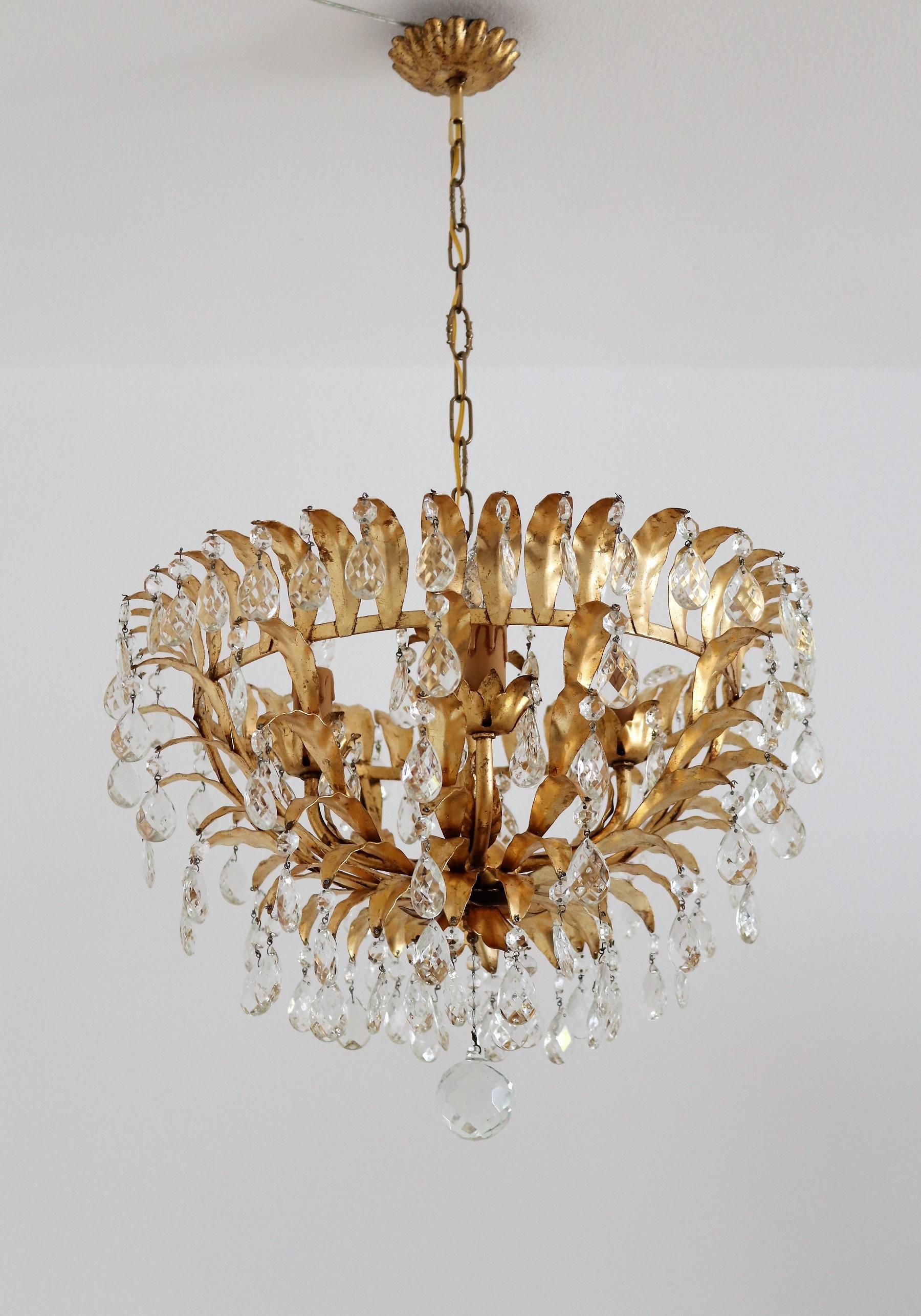 Golden chandelier made of gilt metal and beautifully gilt patinated leaves as well as countless Murano glass crystals.
Made in Italy in the late mid-century by florentine Maison Banci.
The chandelier takes 4 small candelabra bulbs ( max 40W).
All