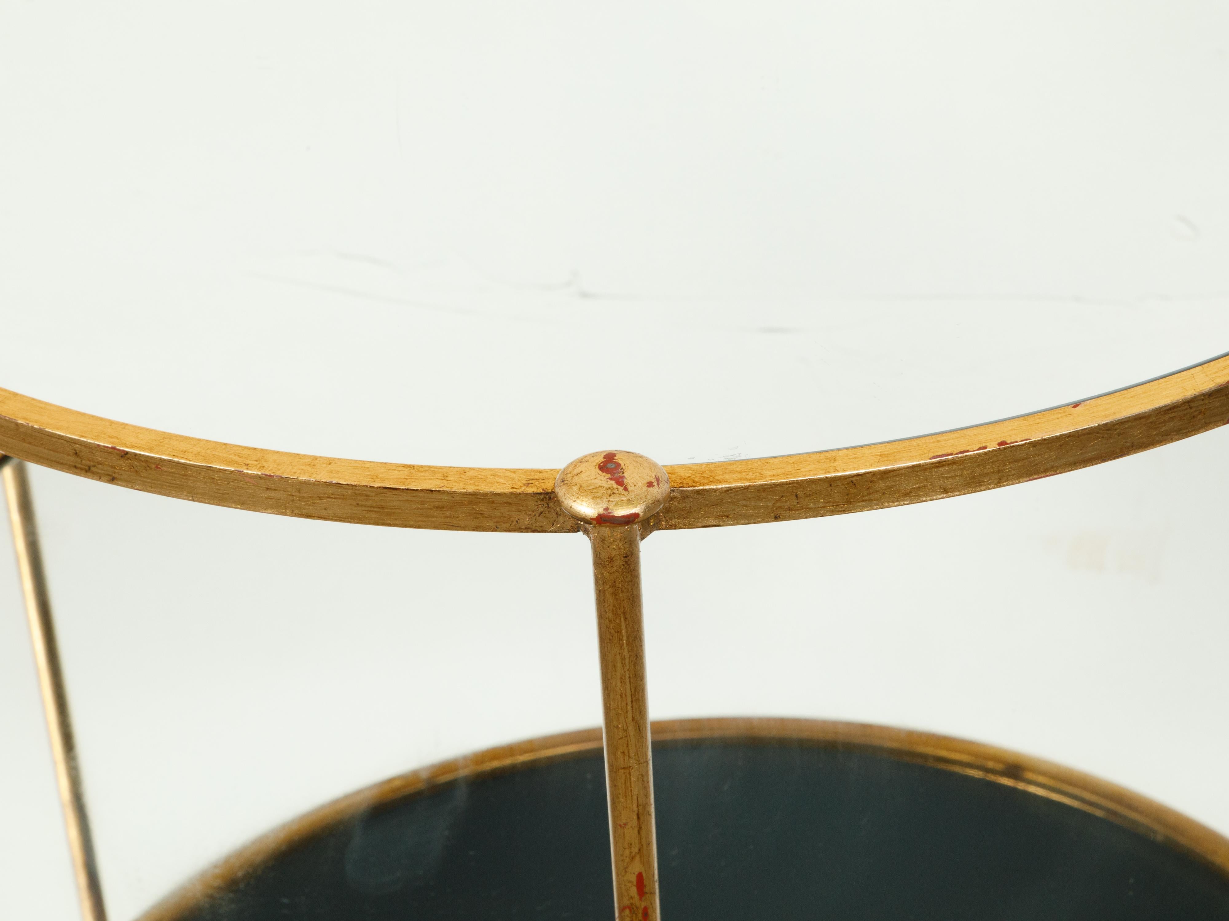 20ième siècle Table d'appoint italienne du milieu du siècle dernier en fer doré à trois niveaux avec étagères rondes en miroir en vente