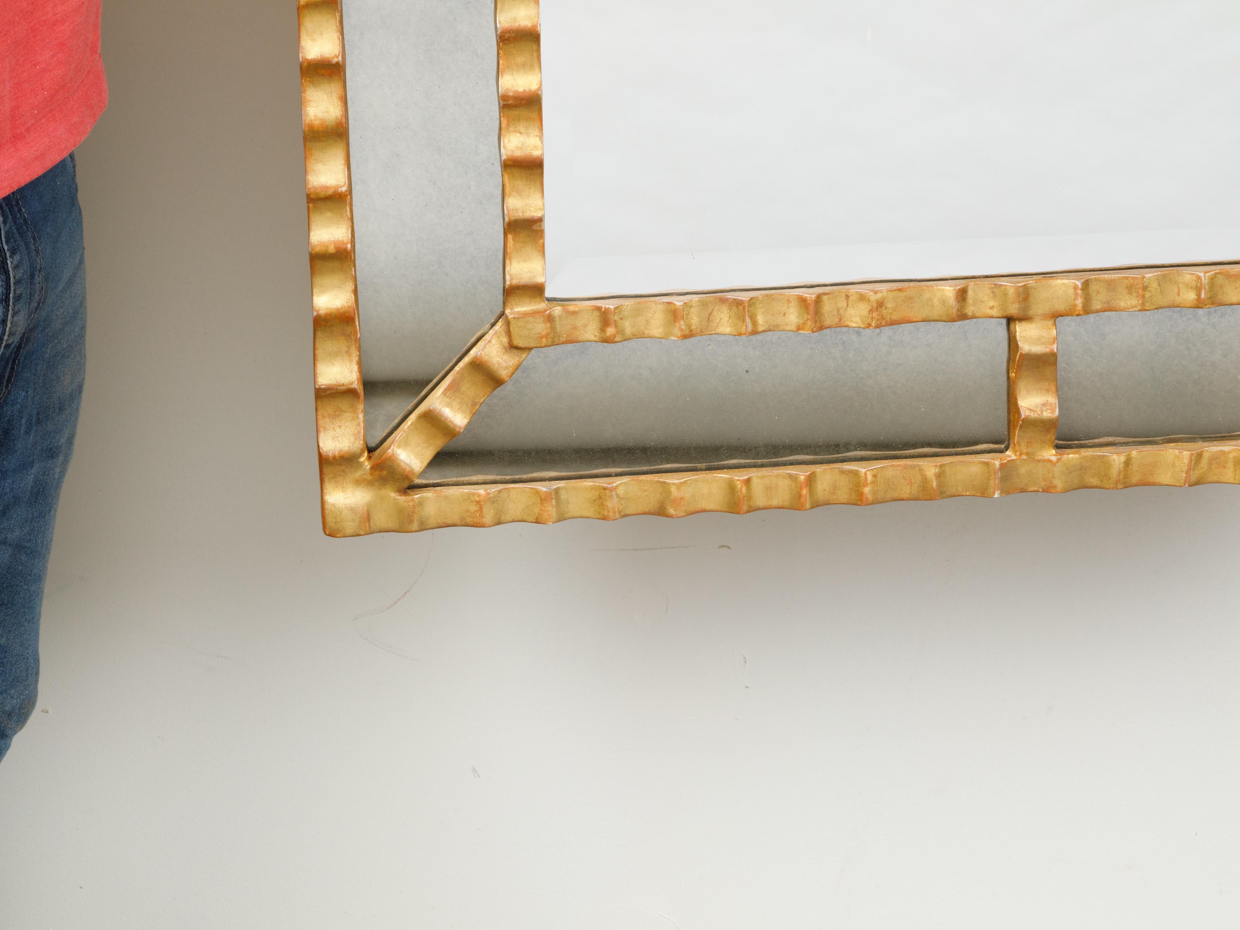 An Italian vintage pareclose gilt metal mirror from the mid 20th century, with grooved motifs. We currently have two mirrors available, priced and sold $5,400 each. Created in Italy during the midcentury period, this gilt metal pareclose mirror