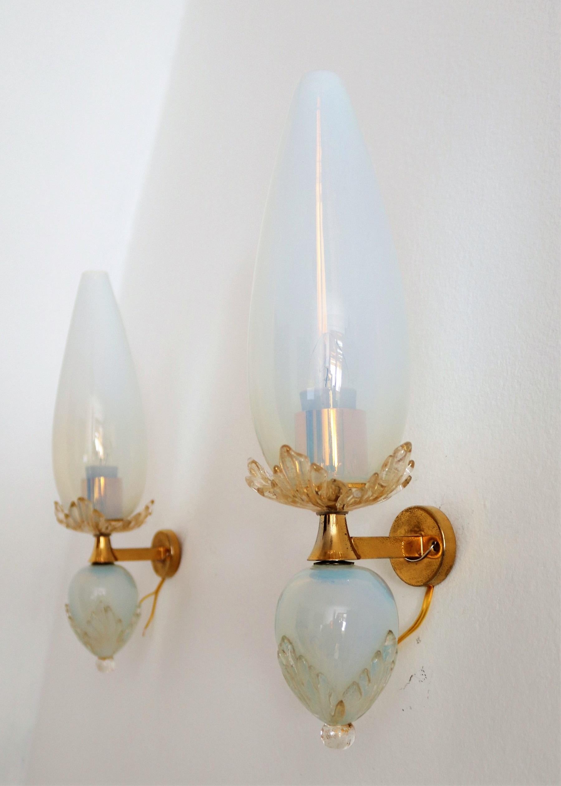 Beautiful pair of wall sconces made by Venini, Murano, Italy in the 1970s.
All glass parts are handcrafted and made of opalescent shiny Murano glass of stunning quality.
Difficult to photograph, much better in person that on the pictures.
The