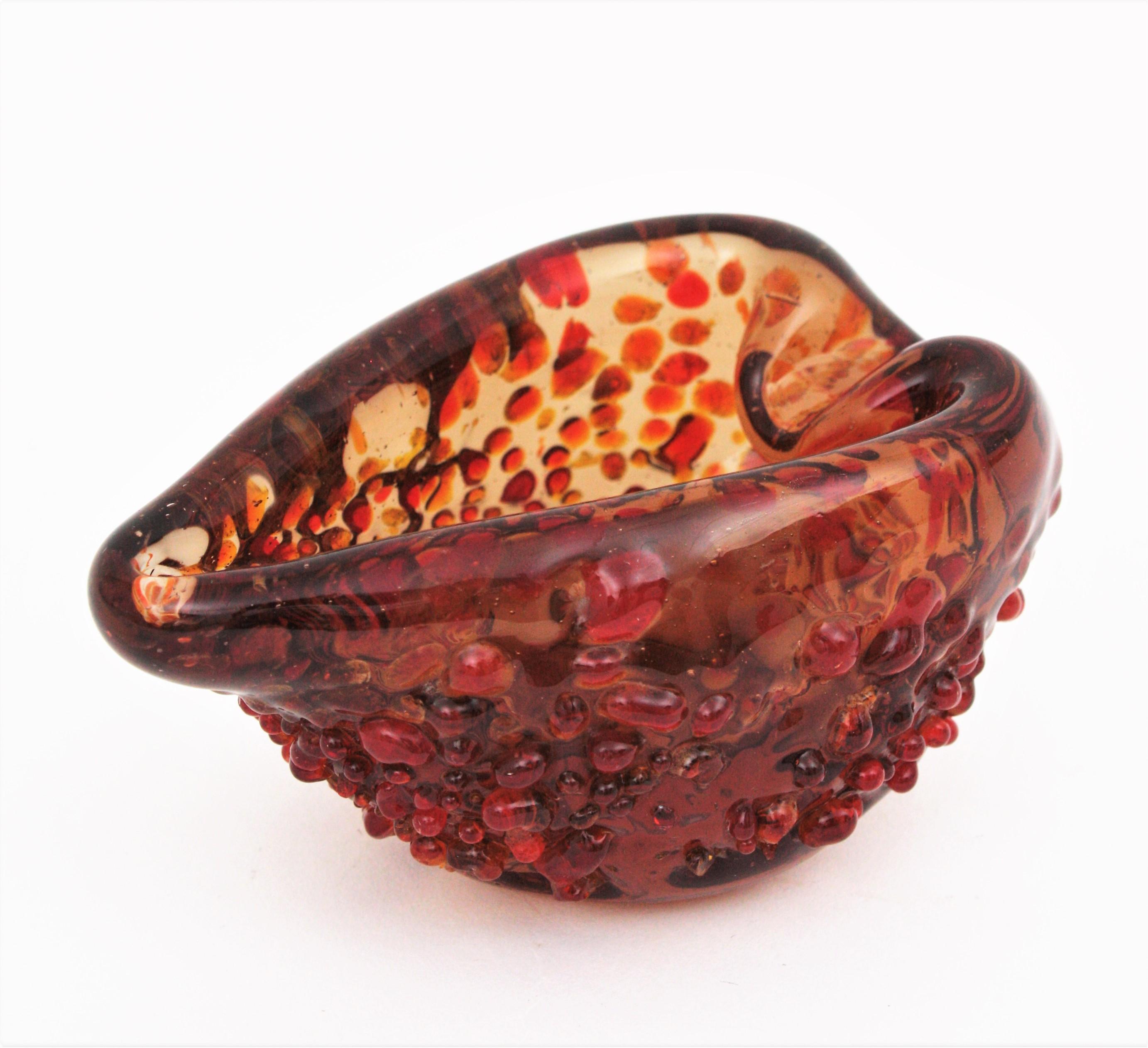 An amazing heart shaped hand blown amber / brown Murano glass bowl or ashtray with applied glass drops. Italy, 1950s.
Orange / burgundy / red glass drops applied on an amber-brown glass surface. Impressive under the sun light.
The piece is in