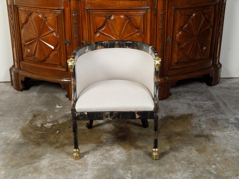 An Italian vintage horn tub chair from the mid 20th century, with gilt rams' heads and new upholstery. Created in Italy during the midcentury period, this tub chair features an elegant horn structure accented with gilt ram's heads. Newly