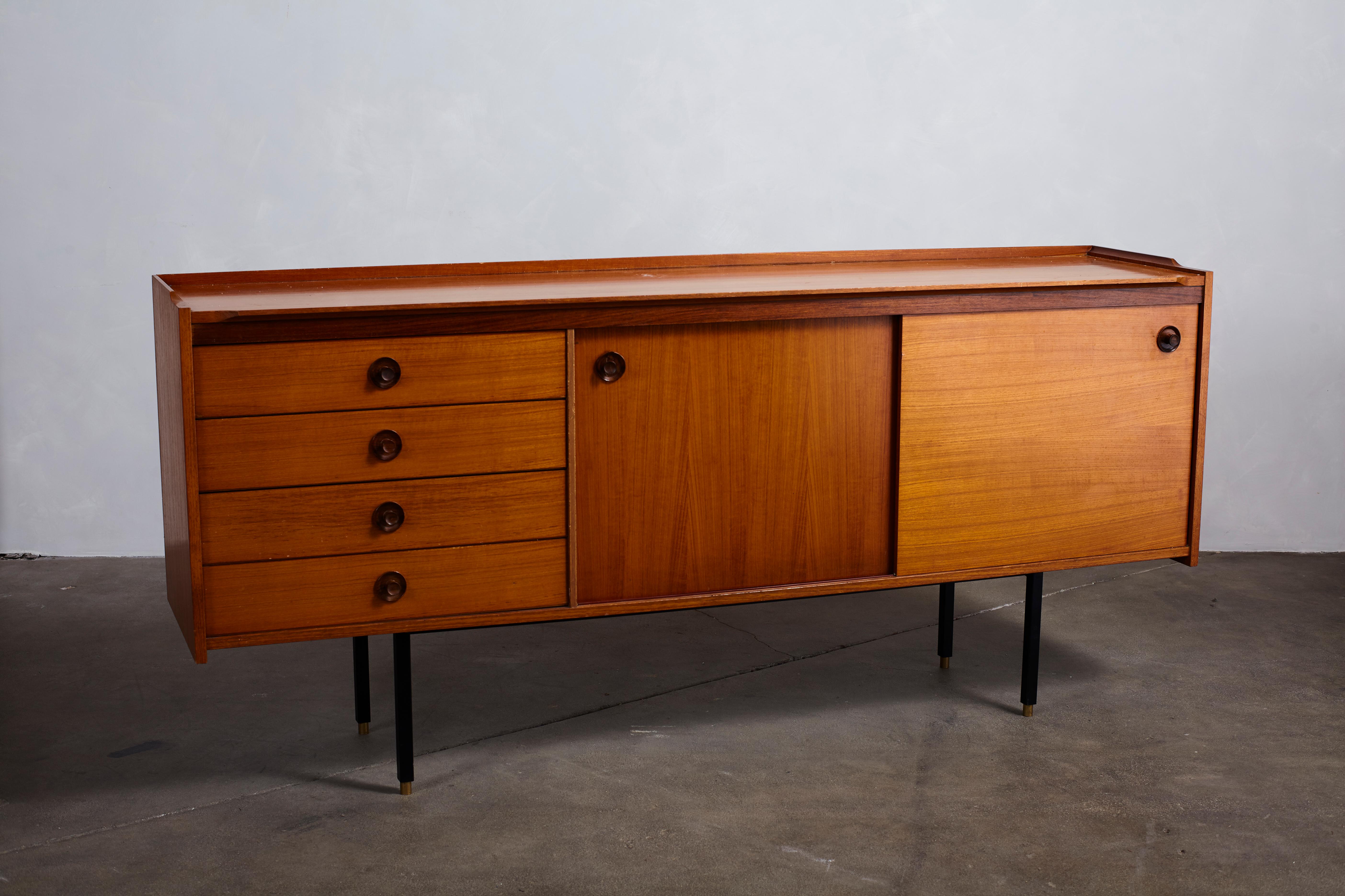 Italian midcentury Ico Parisi style credenza with four drawers and two drawers. Beautiful wood knob details. The credenza sits on a black metal base.