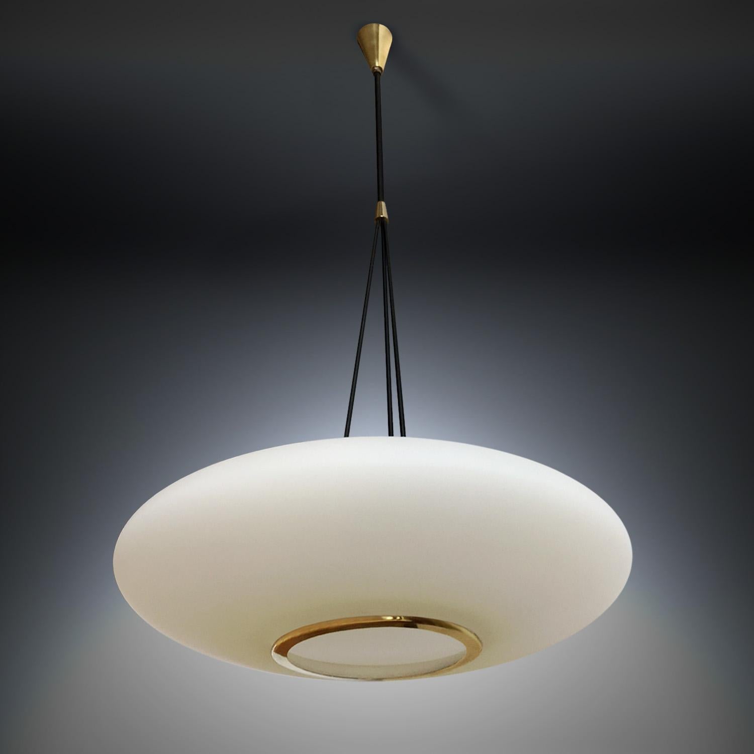 Superb Italian light pendant manufactured by Stilnovo in the 1950s.
The oval brushed satin glass diffuser is suspended from enameled metal arms and finished with original brass details.
It's in very good conditions of the period, with slight signs