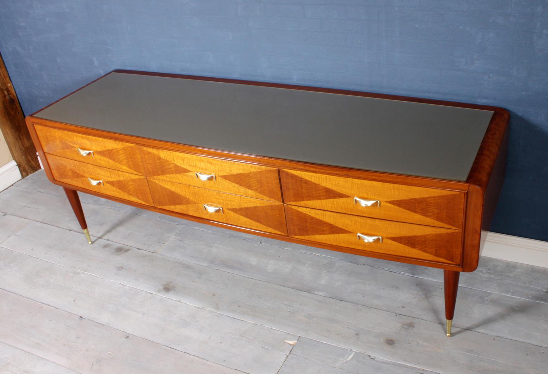 Italian midcentury long chest of drawers

A midcentury long low chest with six drawers in satin wood with brass handles ad feet tips and off white glass top, the chest is in excellent condition throughout and has been fully hand polished

Age:
