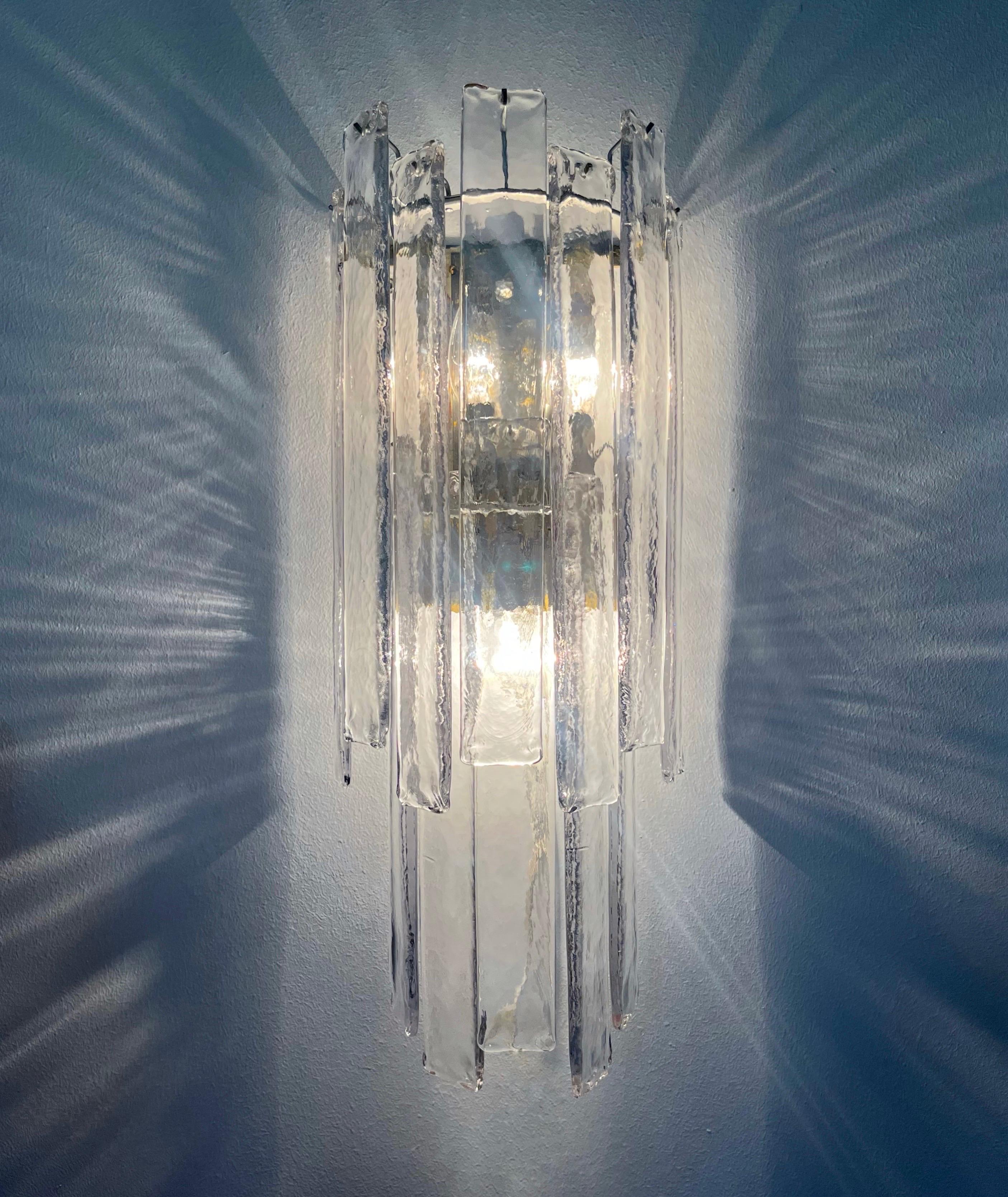 Marvelous, long and large Italian Murano glass Wall Sconces from 1970s. These Wall Sconces were designed and manufactured during the 1970s in Italy by Mazzega. 
Each Sconce is composed by 12 Clear Murano glasses. One more Murano glass included as