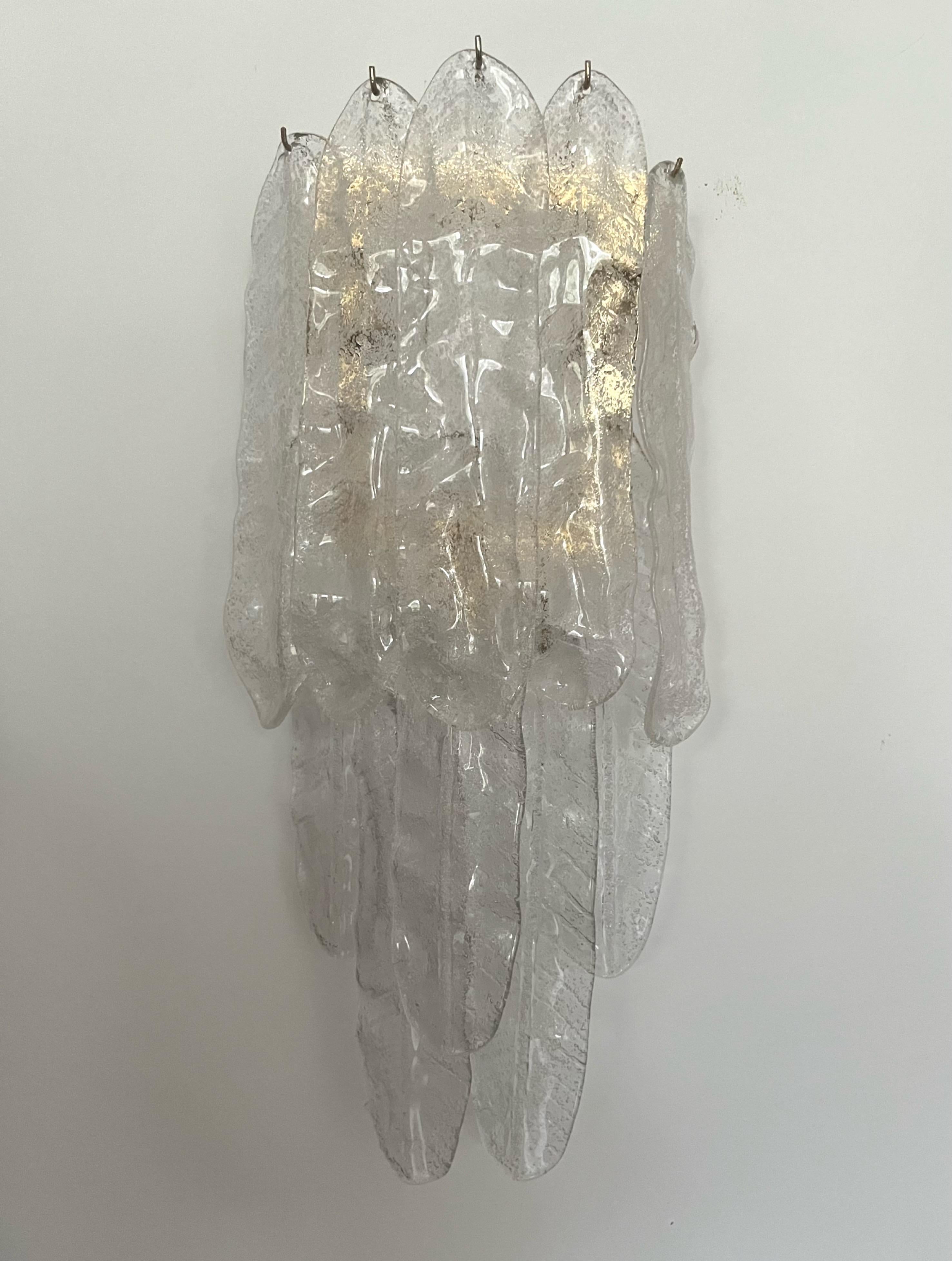 Marvelous and unique Italian Clear Murano glass Leaf Wall Sconce from 1970s. This fixture was designed and manufactured during the 1970s in Italy by Mazzega. 
The Wall Sconce is equipped with 3 light sockets E14. A professional electrician has