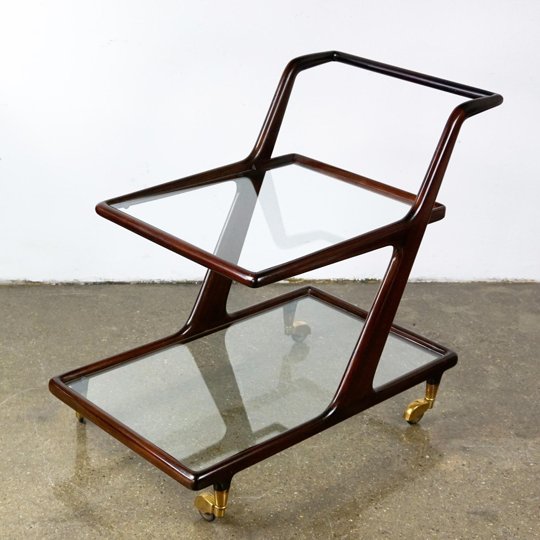 Very elegant and charming Italian midcentury serving cart designed by Cesare Lacca. It´s structure is made of mahogany and it has original brass wheels and renewed clear glass tops. A perfect addition to any midcentury bar or dining room!