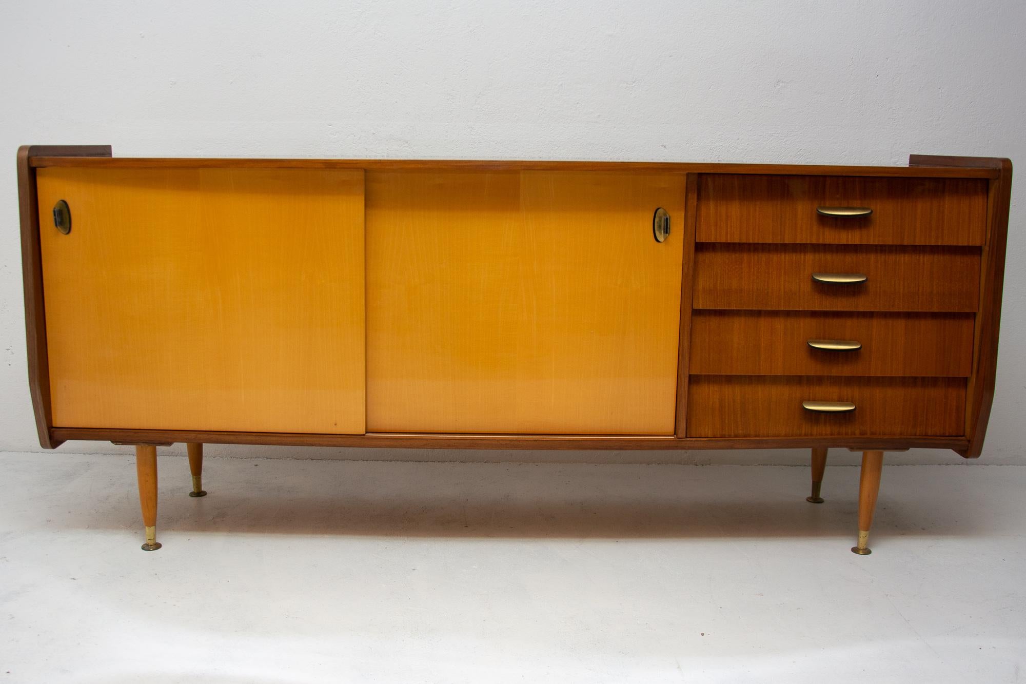 This sideboard was made in Italy in the 1960s. It features a wooden structure and mahogany wood, sideboard stands on beechwood legs. Very simple and attractive design typical of Italian design school. The sideboard is in very good vintage condition