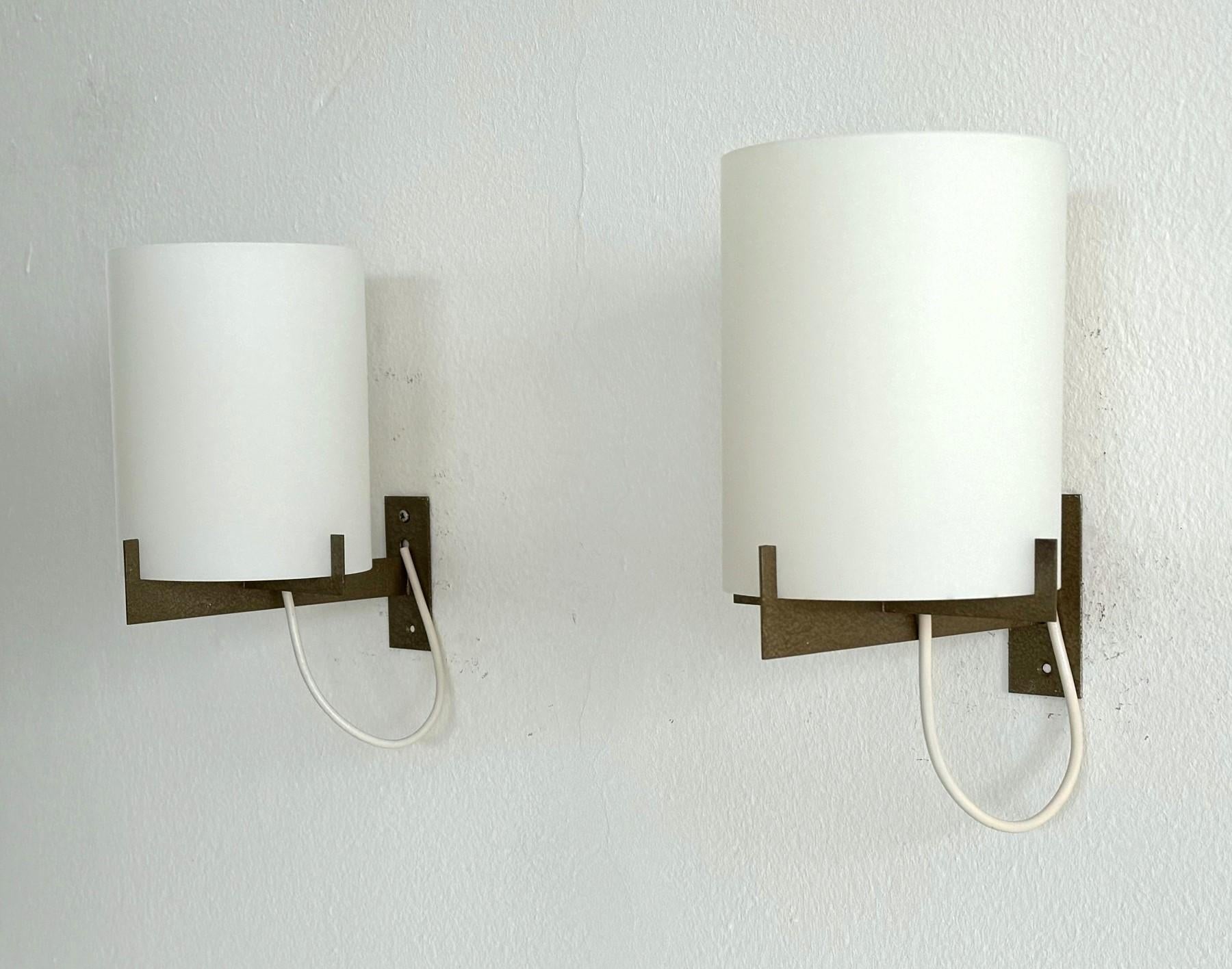 Schönes Paar minimalistischer, eleganter Wandleuchter aus der Mitte des Jahrhunderts, hergestellt in Italien in den 1960er Jahren.
Erinnert an den Stil von Ignazio Gardella.
Die Leuchtensockel bestehen aus lackiertem Metall und sind sehr