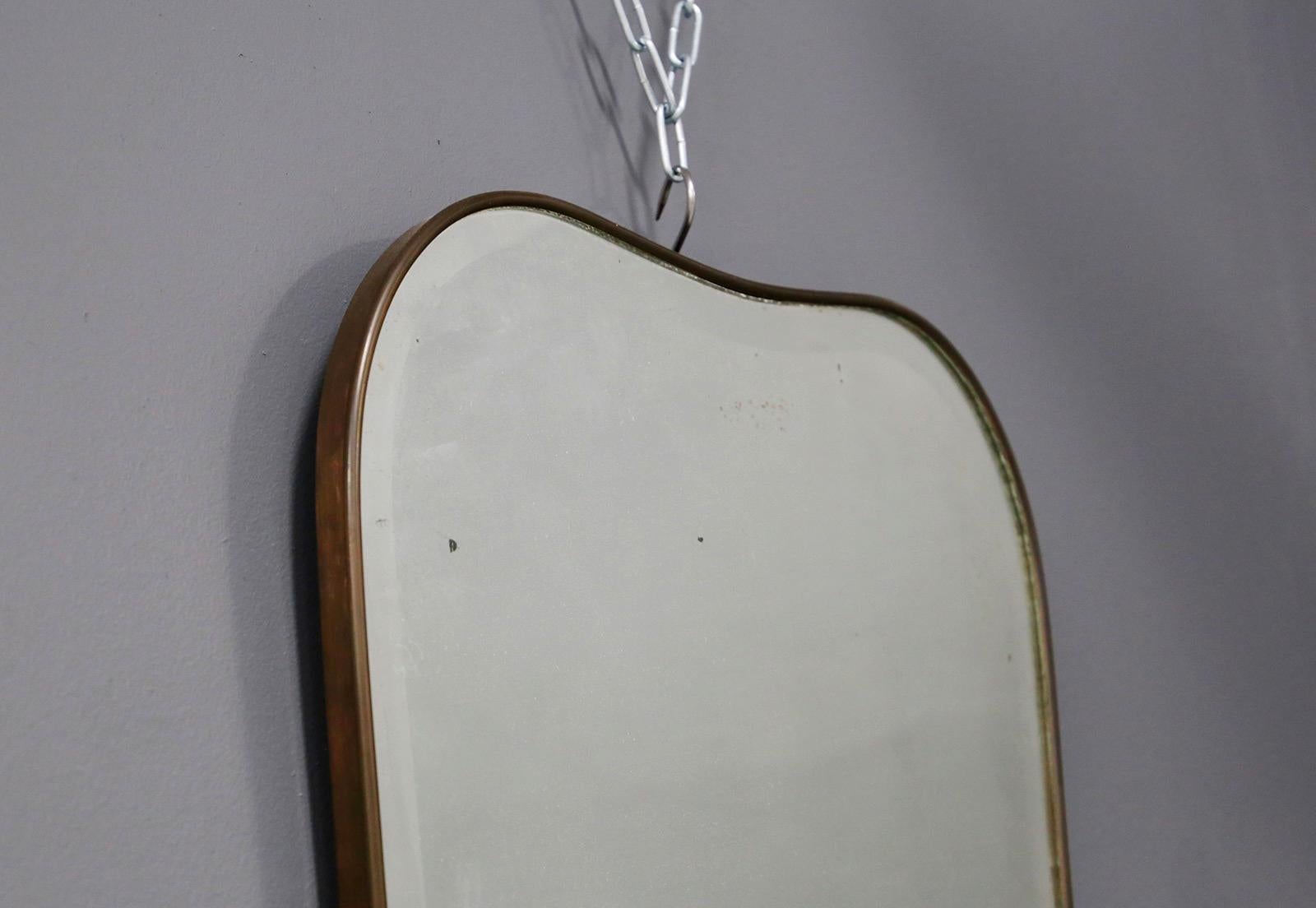 Elegant wall mirror of the 1950s Italian attributed to Gio Ponti for Fontana Arte production.
The mirror is made of curved brass with slight wear due to age and use. The peculiarity of the mirror is its heart-shaped shape typical of the Pontian