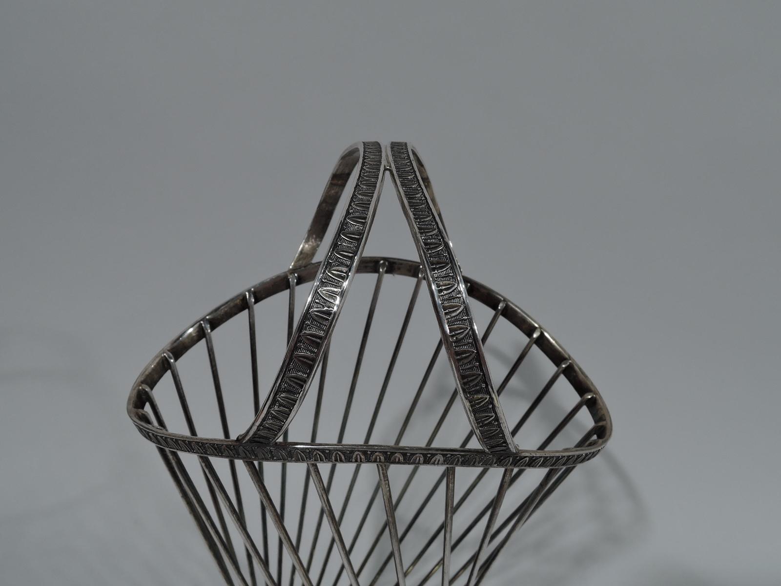 Italian Mid-Century Modern Classical 800 silver basket. Ovoid and tapering body with vertical and twisted wire. Two joined and slanted c-scroll handles mounted to asymmetrical rim. Rests on solid dome foot. Stylized egg-and-dart ornament on rim,