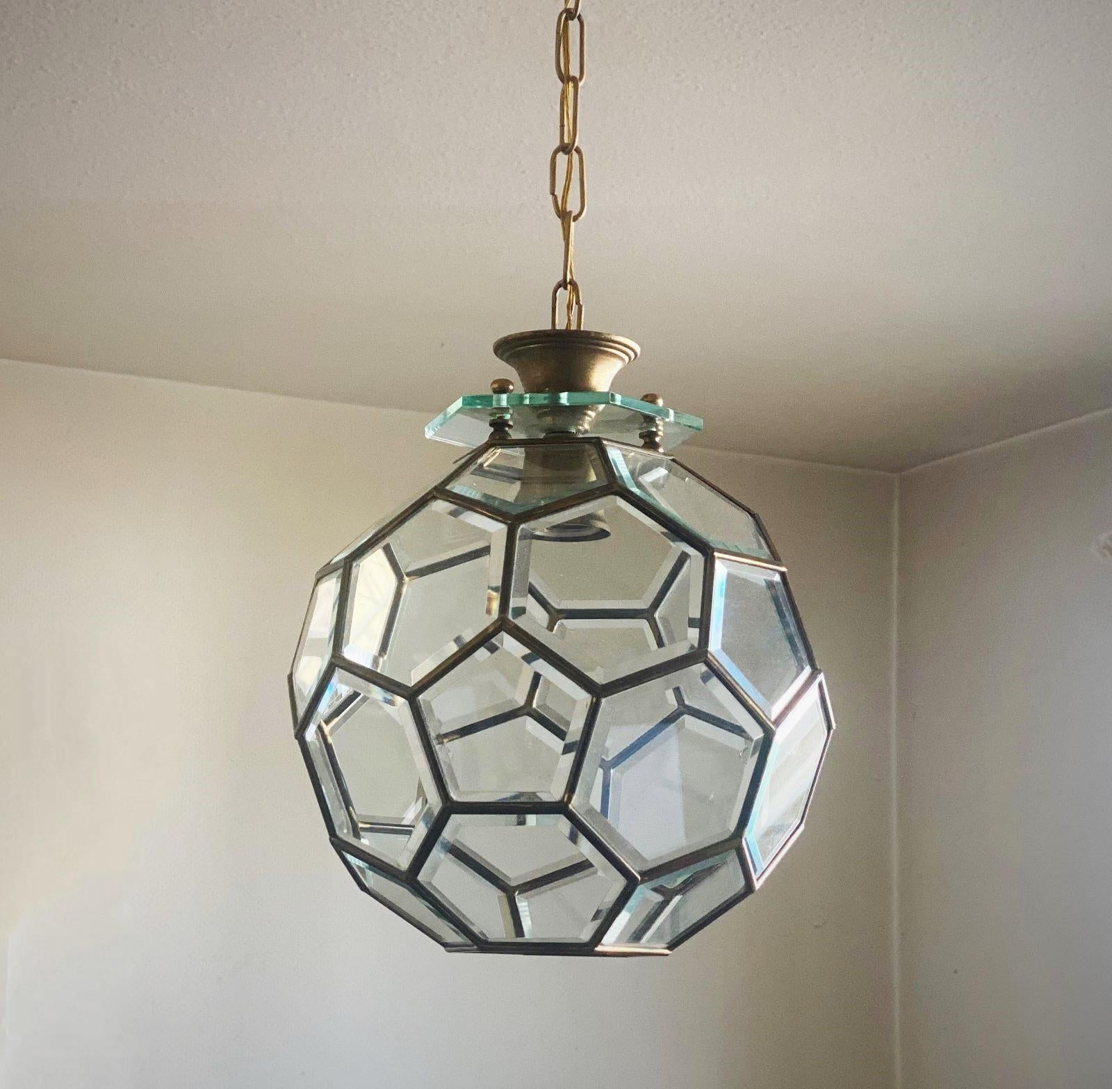 A Mid-Century Modern Fontana Arte pendant or lantern, Italy, 1950s. Geometrical faceted ultra clear glass panels with brass beaded frames, brass canopy and chain. It takes one Edison E27 large sized screw bulb. The lantern is in fine vintage