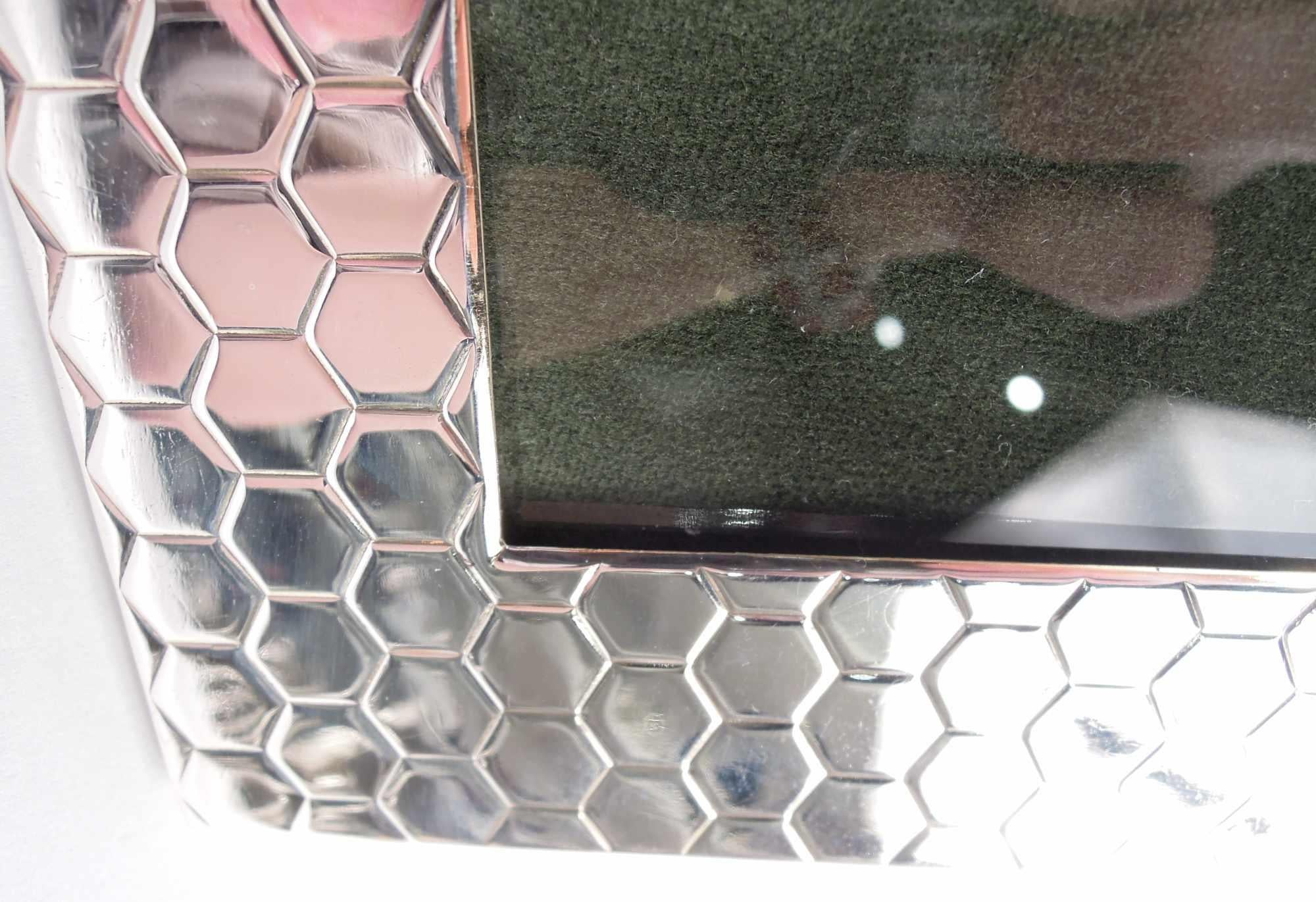 Cadre photo en argent sterling de style Midcentury Modern. Fenêtre carrée dans un cadre large et plat avec un motif en nid d'abeille incisé sur le devant ; les bords sont unis. Doublure en verre et velours et dos avec support de chevalet à