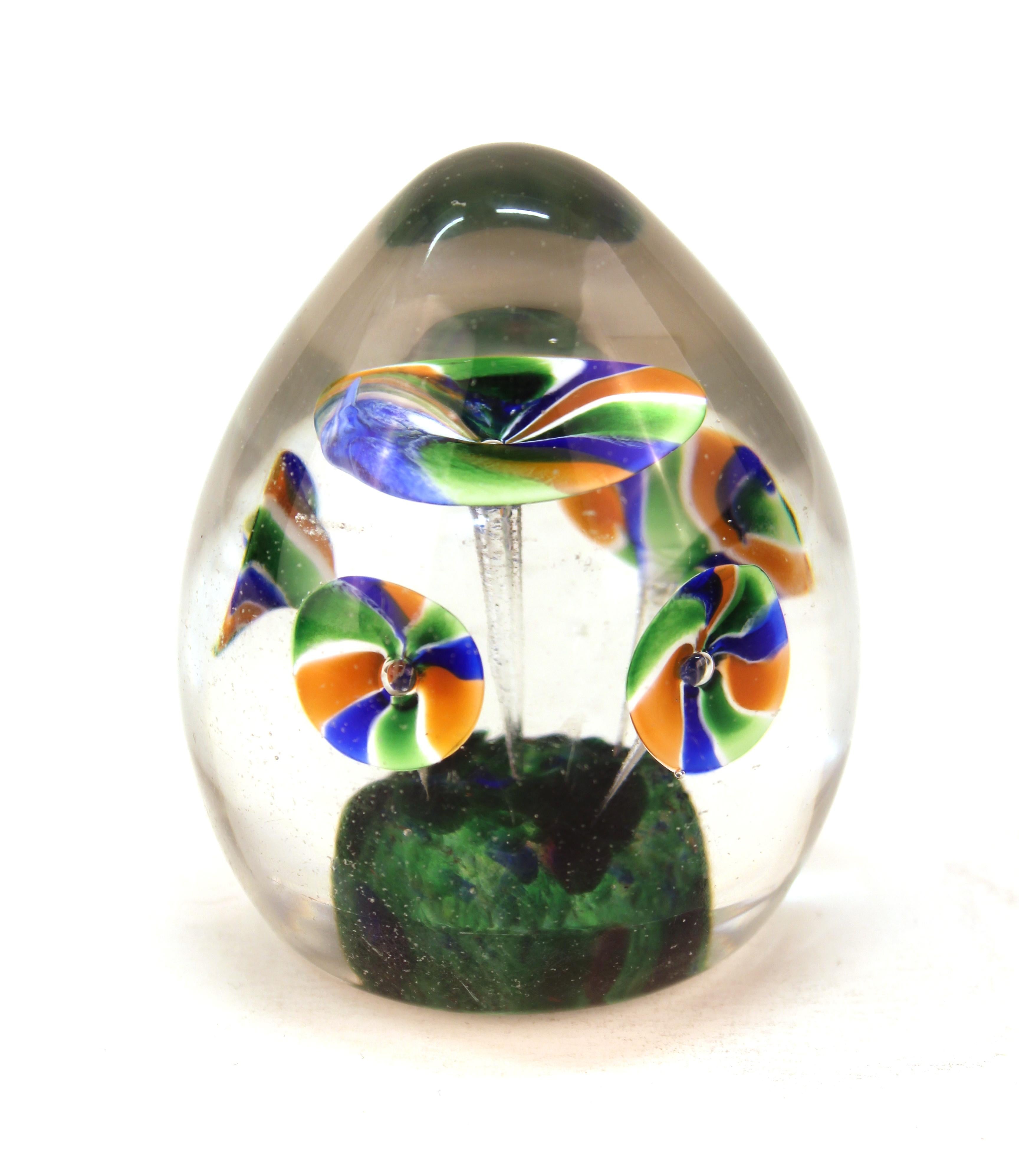 Italian Mid-Century Modern Murano art glass paperweight in elongated egg-shape, with floral motif and old price-tag on bottom. The piece is in great vintage condition with some wear to the bottom.