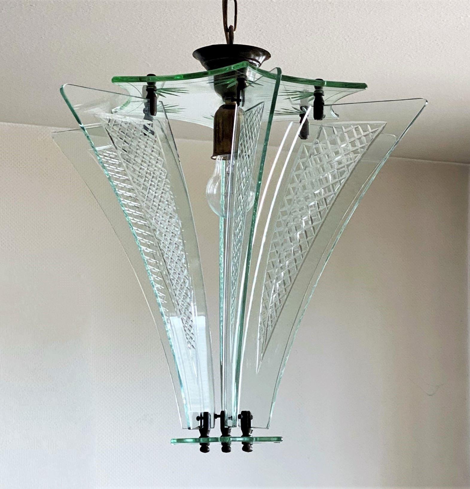 Rare and exceptional hand blown Murano ultra clear cut glass pendant or lantern by Fontana Arte, Italy, 1950s. This fixture is composed by six beveled glass panels with elegant cut pattern fitting to two cut glass disks forming a star design, brass