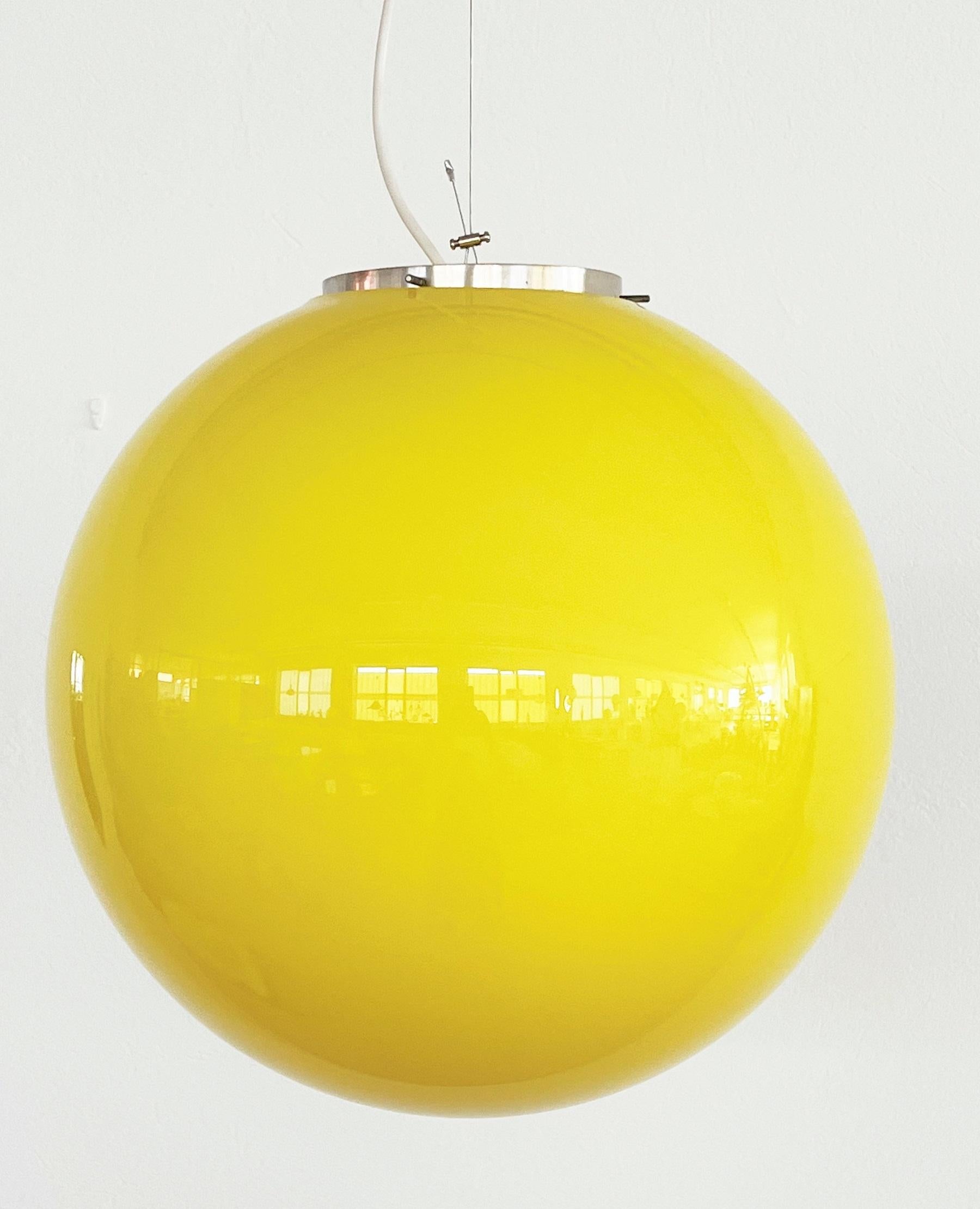 Beautiful Italian ceiling lamp of the 70s. Typical pop art style.
The large shiny Murano glass ball of high quality manufacture is in bright lemon yellow and in excellent condition, also the upper glass rim is flawless.
The suspension device of