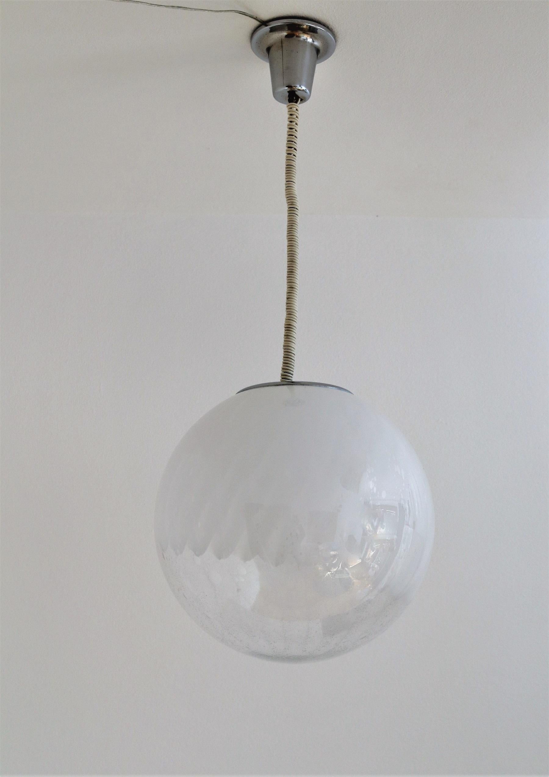 Beautiful and elegant Murano glass globe pendant lamp with gorgeous glass design, chrome details and original curly cable. The curly cable can be exchanged on request to a modern steel cable and white wire.
Attributet to Venini, Made in Italy in the