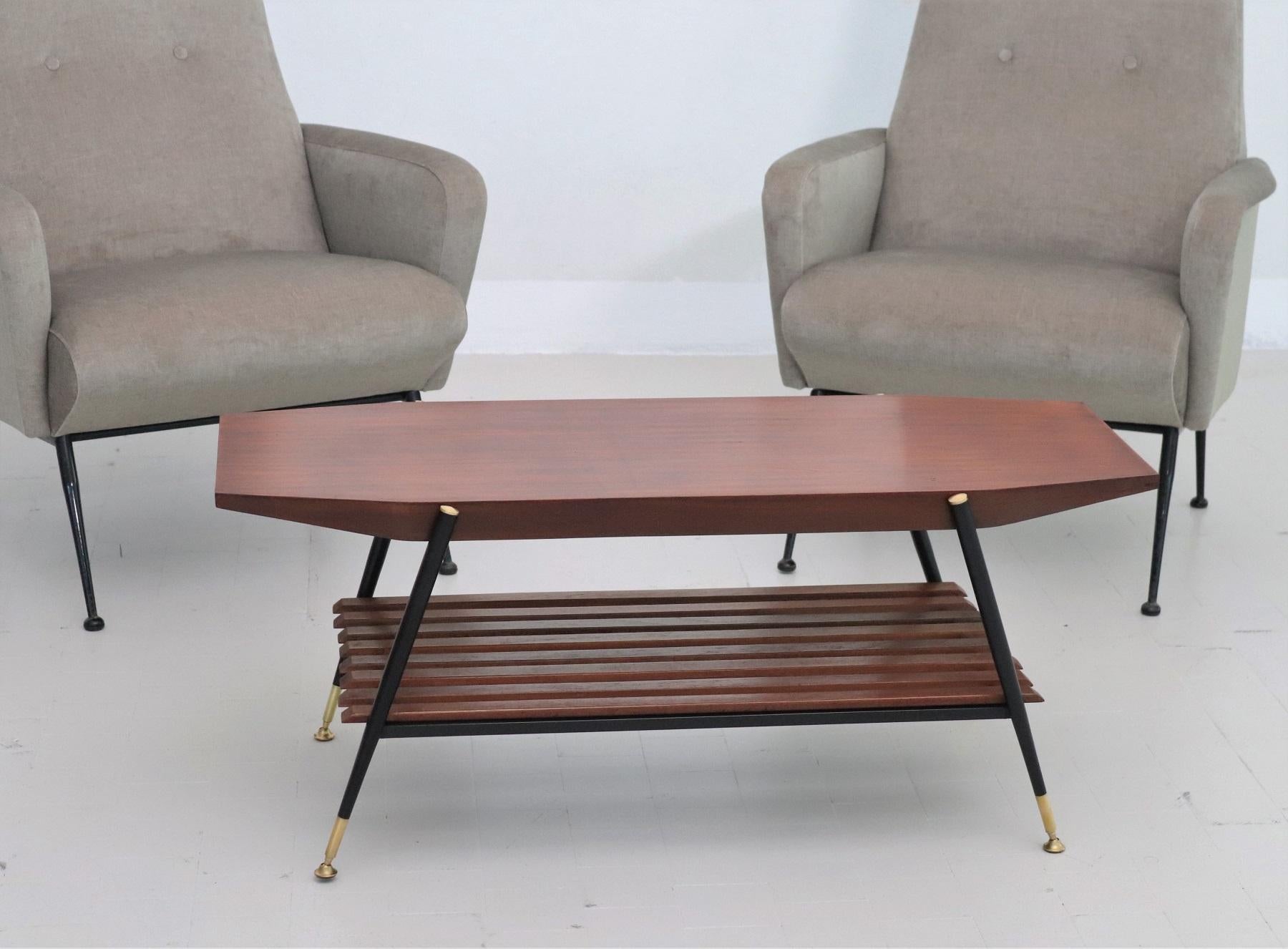 Beautiful octagonal design coffee table from the Italian mid-century, Made in Italy in the 1960s.
Made of a solid metal frame, varnished in black color, with brass details, which are polished.
The lower wooden shelf parts are made of chestnut wood