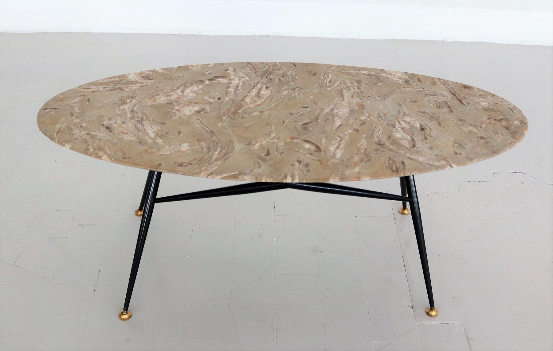 Beautiful particular coffee table in oval shape with gorgeous marble top in sand - beige - taupe color with orange inclusions and metallic legs with adjustable brass tips.
Made in Italy during the 1950s.
This marble top has a beautiful natural