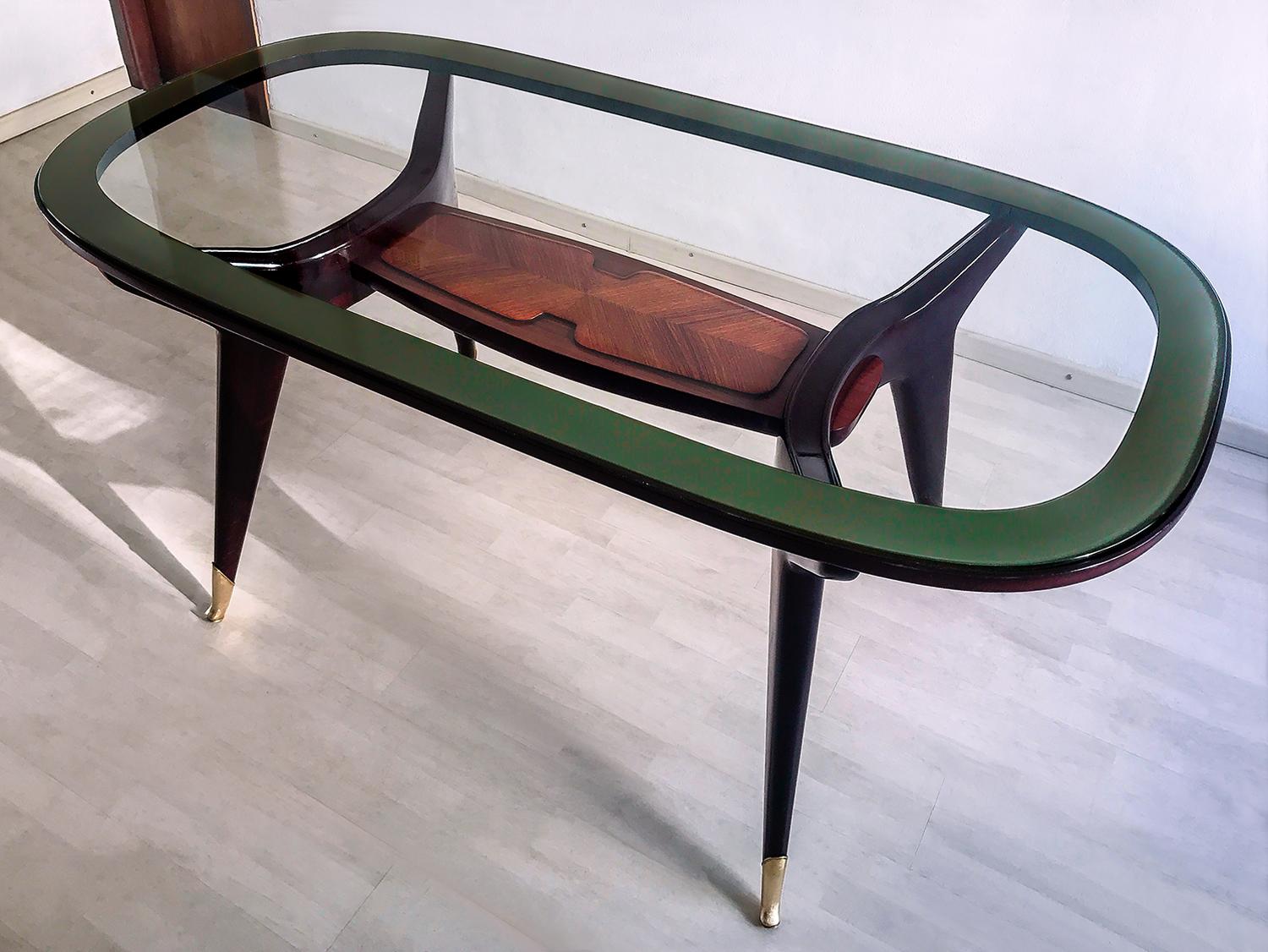 Stunning dining table, very well designed by Vittorio Dassi in the 1950s.
The rosewood structure has tapering legs finished with fine brass sabots, and its unique design is given by the sinuous shape of the arms that support the thick oval