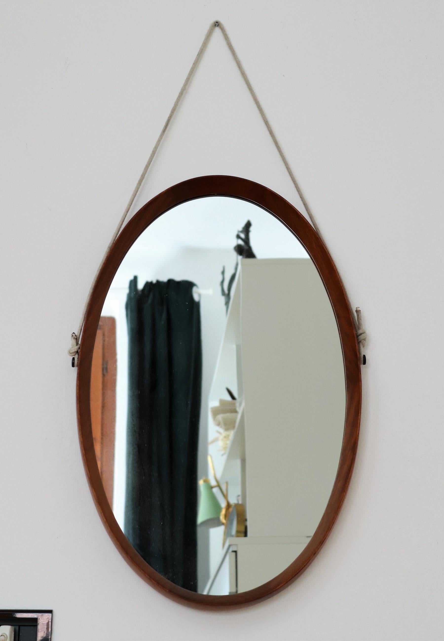 Oval vintage Italian mid-century wall mirror made of teak wood, Italy, in the 1960s.
The oval frame is made of excellent craftsmanship, please see all detail pictures.
The original cord for wall hanging on both sides is fixed on two big