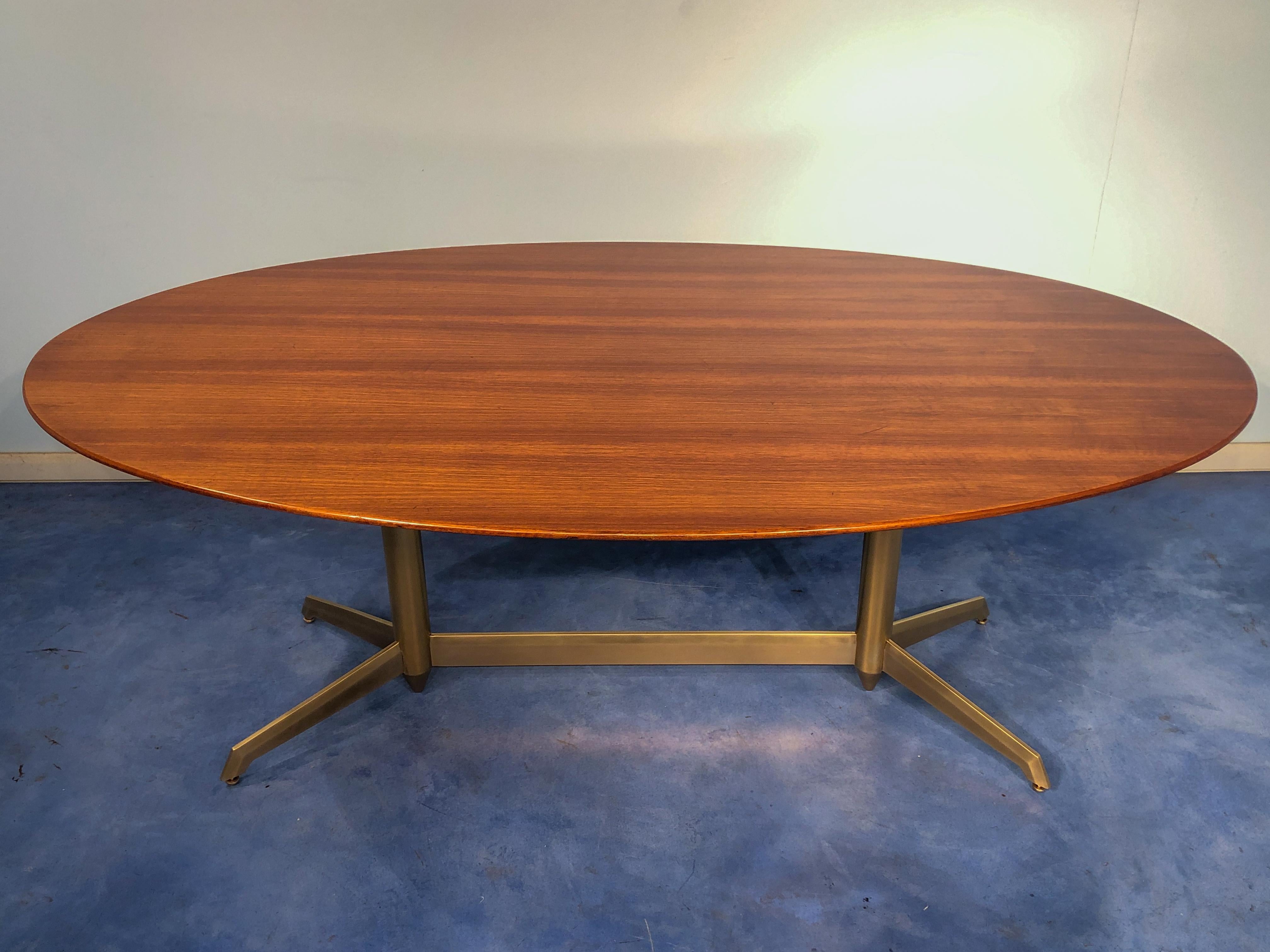 Fantastic shaped Italian midcentury oval dining table, 1950.
The base frame is totally made in precious stained brass with line feet truly unique, a sign of a high-level commission.
The top has a really elegant oval shape with a superb walnut