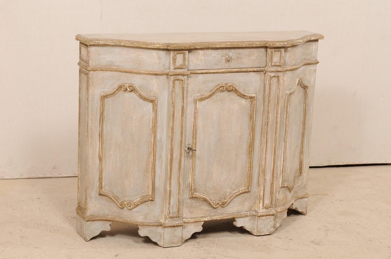 An Italian midcentury painted wood console chest. This small-sized vintage cabinet from Italy features a beautifully scalloped and projected front with top mimicking the shape beneath. The case is trimmed with three panels, each featuring volute