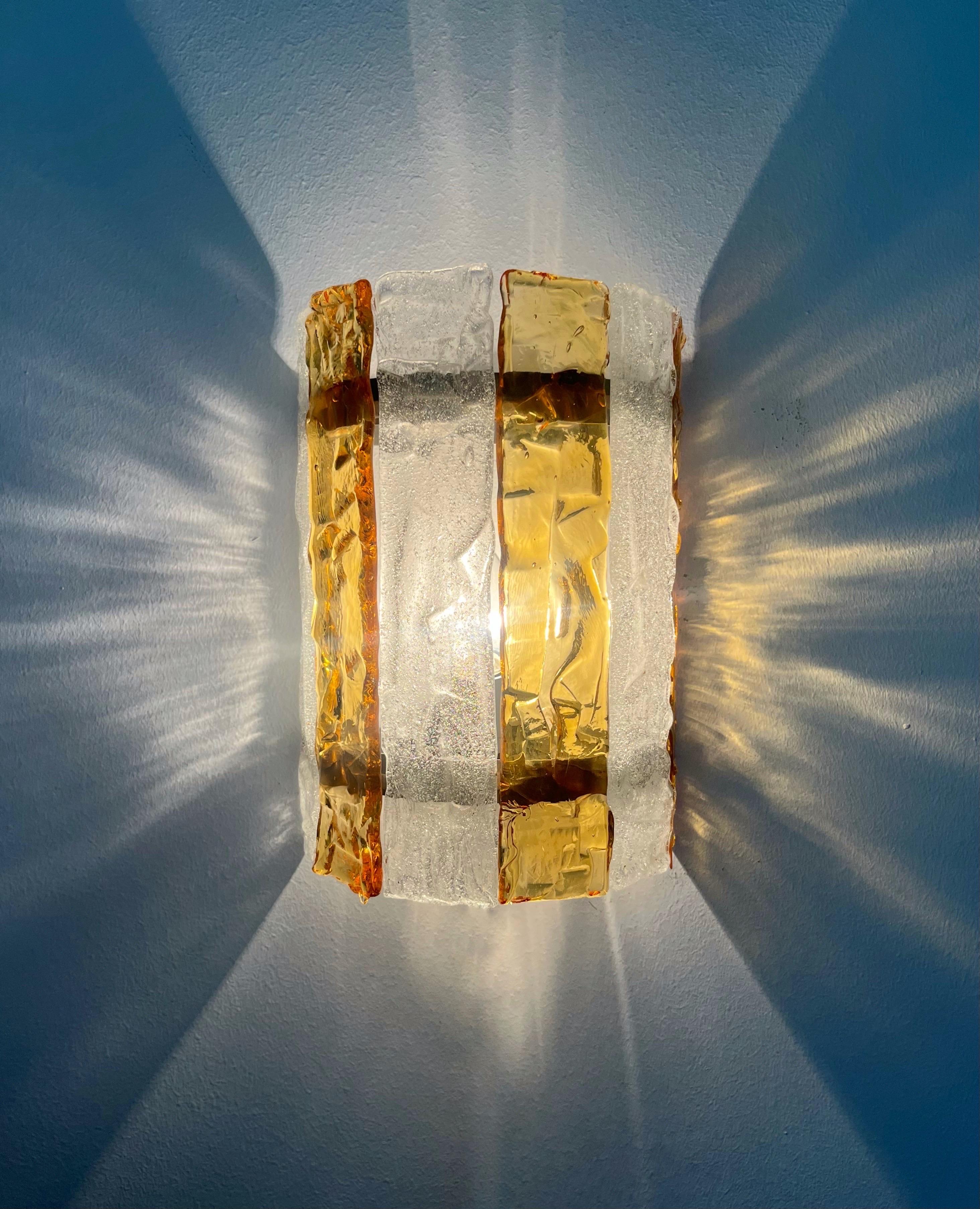 Splendida e deliziosa coppia di applique italiane in vetro di Murano trasparente e ambrato, risalenti agli anni '70. Questi apparecchi sono stati progettati e prodotti negli anni '70 a Murano (Italia) da Mazzega.
Ogni applique è dotata di una presa