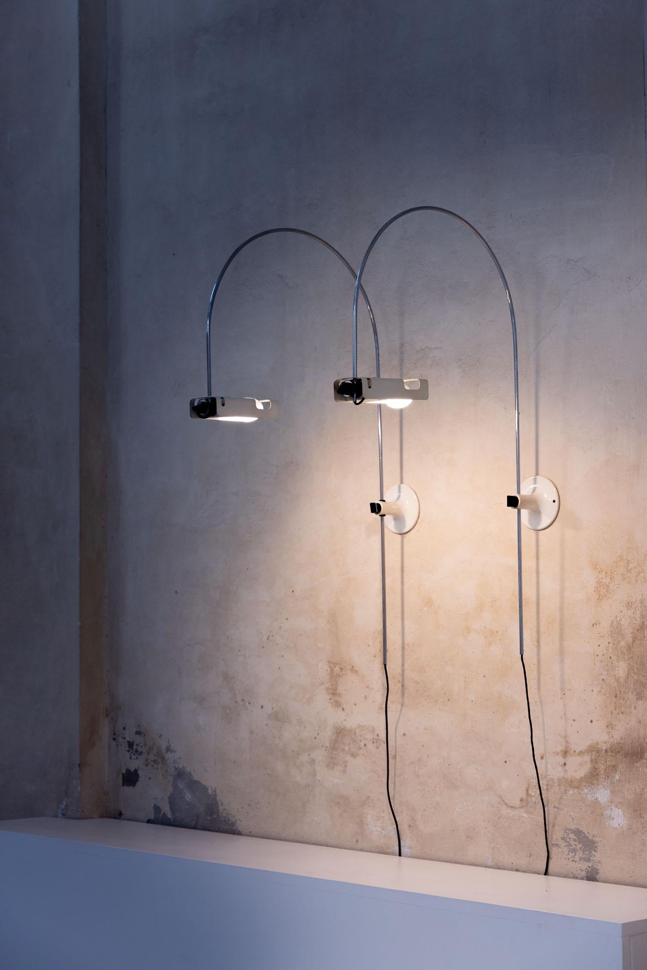 Rare pair of iconic Spider wall lamps designed by Joe Colombo for Oluce in 1965. 
Original metal structure and lacquered lampshade, the two lamps are composed of a single lighting body, conceived as a response to a special horizontal spot bulb,