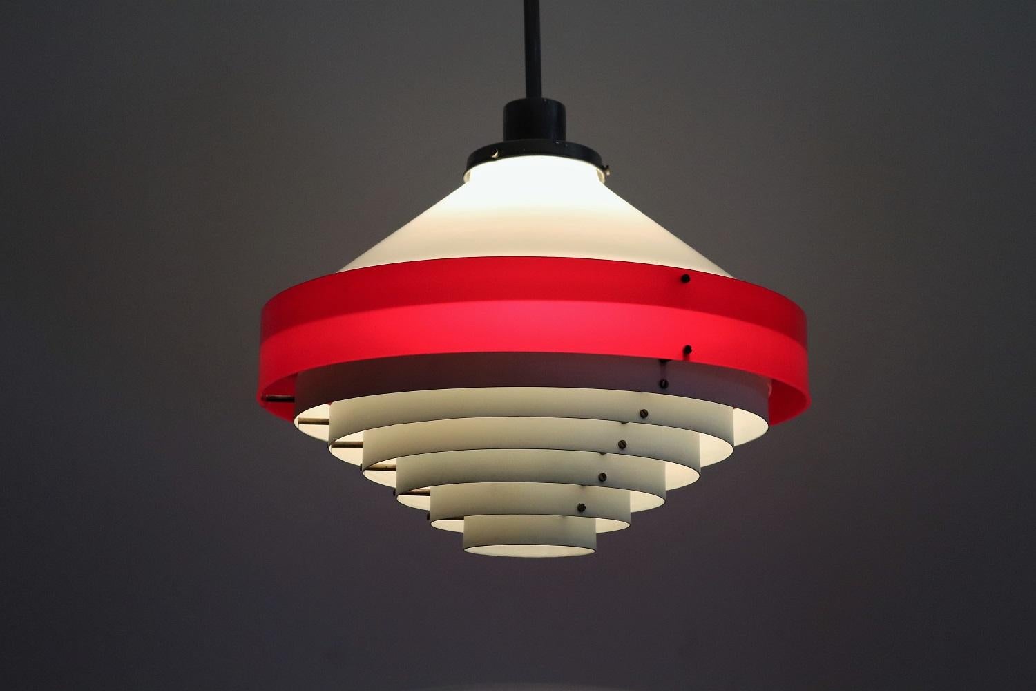 Belle lampe pendante italienne du milieu du siècle dans un style scandinave !
Attribué à Stilnovo Italy, fabriqué en Italie dans les années 1950.
Le dôme blanc supérieur et l'anneau rouge sont en acrylique brillant, les anneaux blancs inférieurs