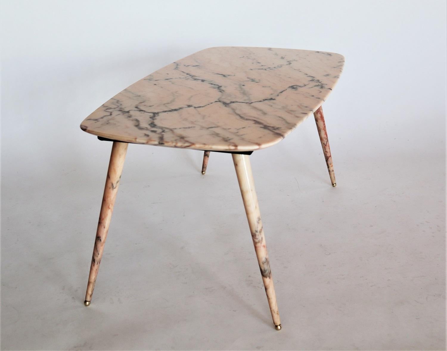 Beautiful coffee table with gorgeous pink marble top and marble legs with brass tips. Very rare to find this type of table with the marble legs.
Made in Italy during the 1950s.

The pink marble has a beautiful natural marble design with strong