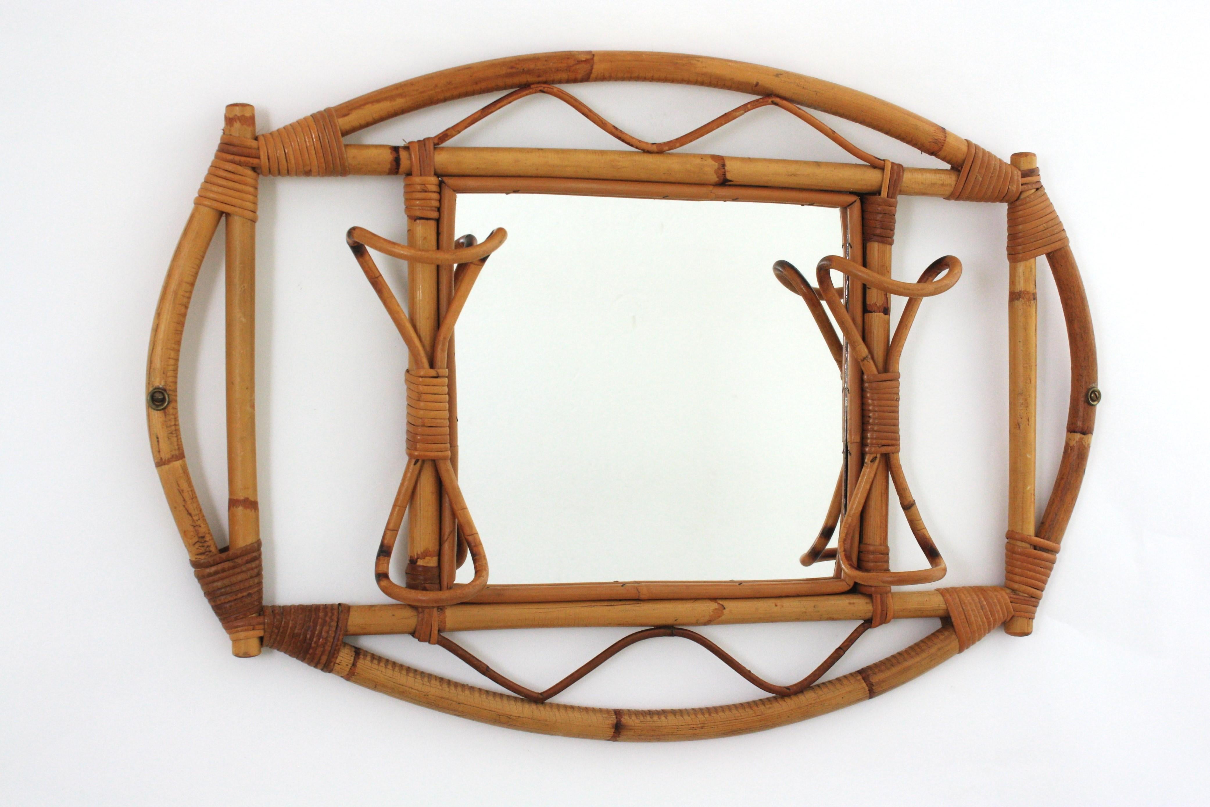 Accattivante specchio/appendiabiti da parete in rattan e bambù. Italia, anni '60
Questo specchio artigianale è stato progettato nello stile di Franco Albini.
Ha un bellissimo design con una struttura in bambù accentuata da dettagli in rattan e due