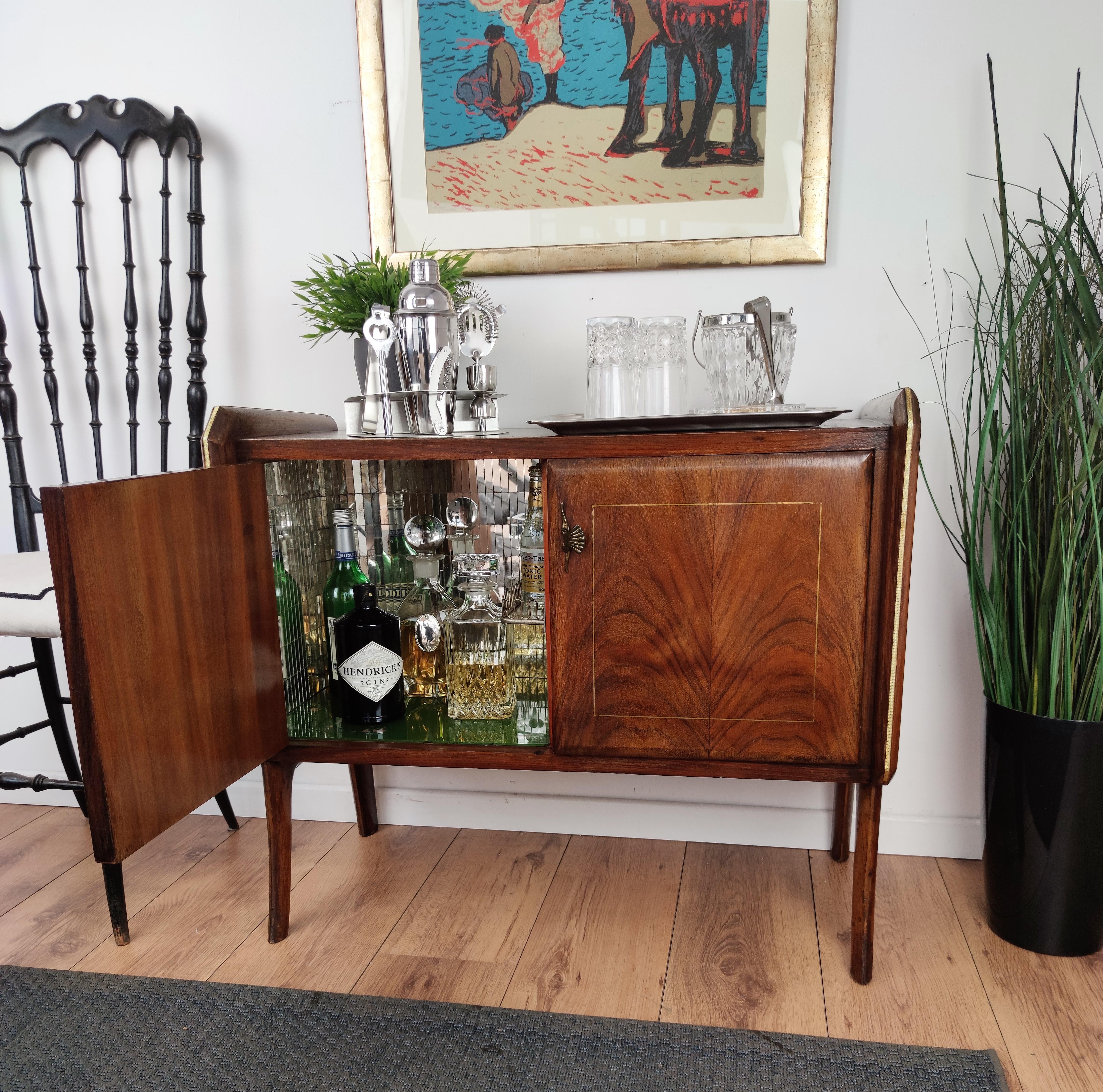 Beautiful and elegant Italian dry bar cabinet in the typical design and shapes of Mid-Century Modern pieces, in walnut and burl wood, with great decorative use of the veneer and inlayd geometric gilt motives on the two doors an amazing interior part