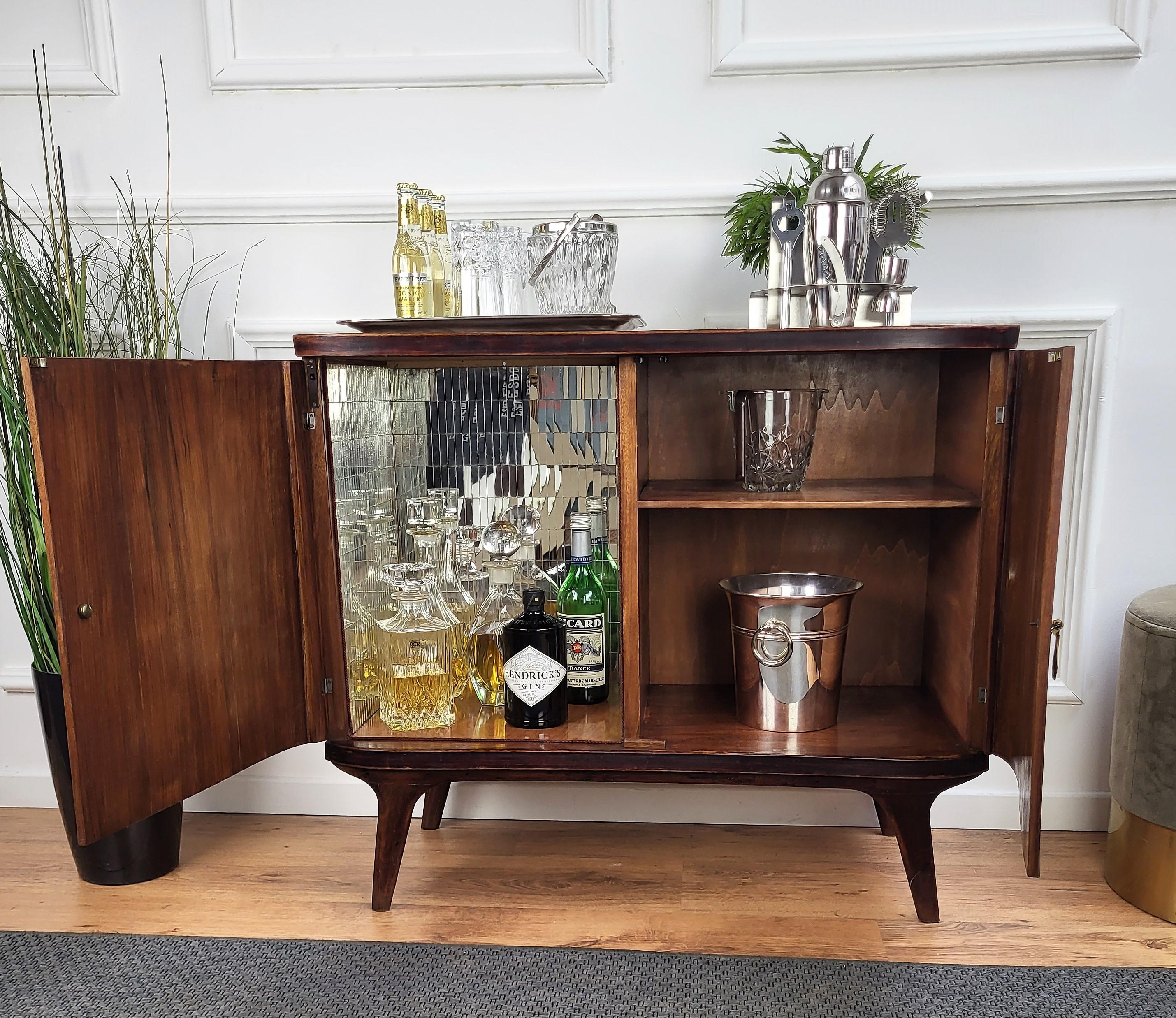 Beautiful and elegant Italian dry bar cabinet in the typical design and shapes of Mid-Century Modern pieces, in walnut and burl wood, with great decorative use of the veneer and geometric gilt motives on the two doors with an amazing interior part