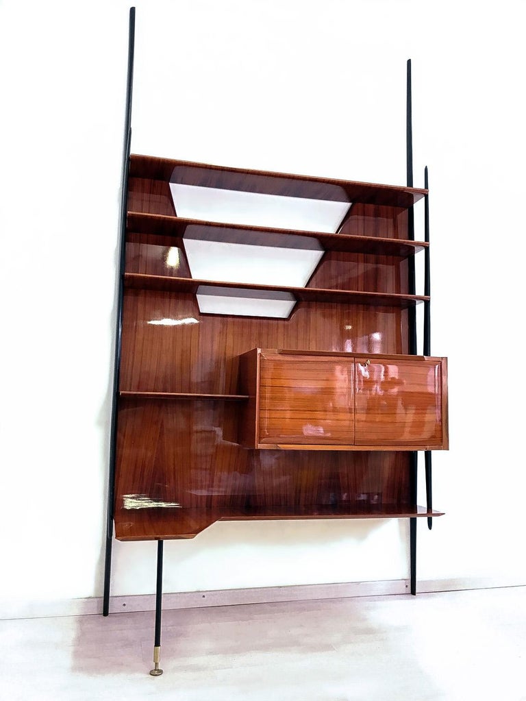 Stunning Italian wall unit designed by Vittorio Dassi in the 1950s.
The structure is supported by uprights with the form of long lances in ebony stained wood.
The item is in very good conditions of the period, with minor signs of wear consistent