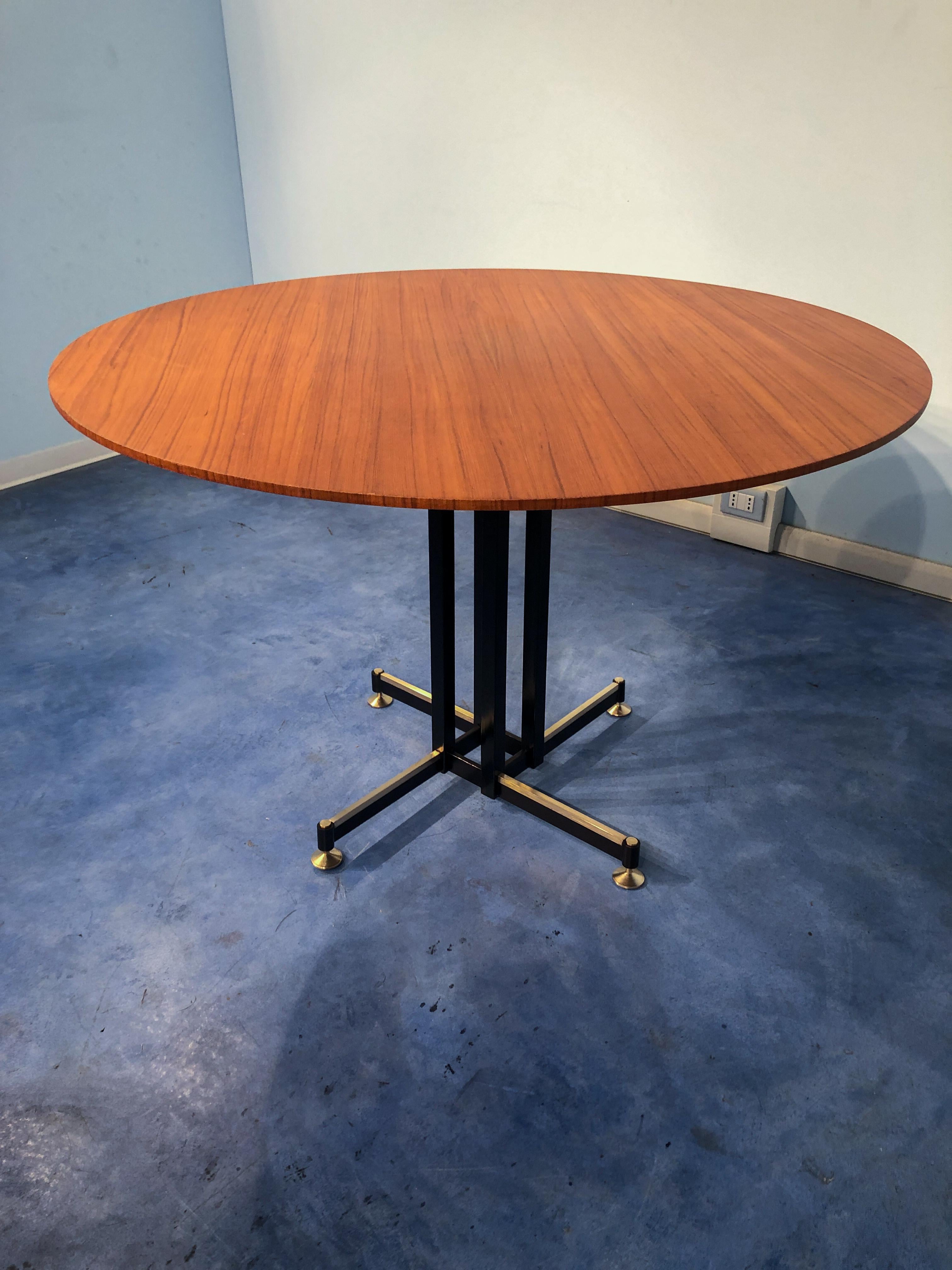 Italian midcentury teak veneer dining table, beautiful black architectural base with precious brass feet that can adjust for height and leveling purposes, round teak wooden top with really nice grain and color, completely restored very good