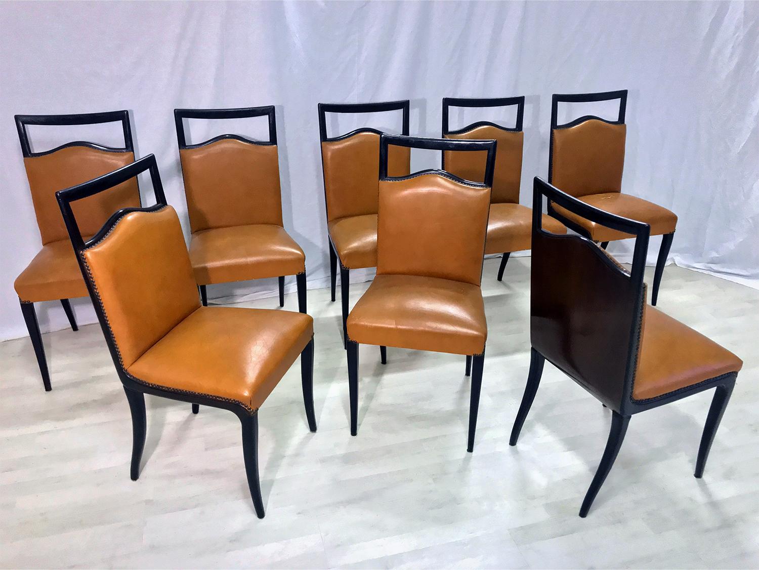 Elegant lines and solid structures for this set of eight dining chairs designed by Vittorio Dassi in the 1950s, upholstered with faux leather of a beautiful rust color.
The ebonized wood surfaces, as well springs and padding, are to be considered