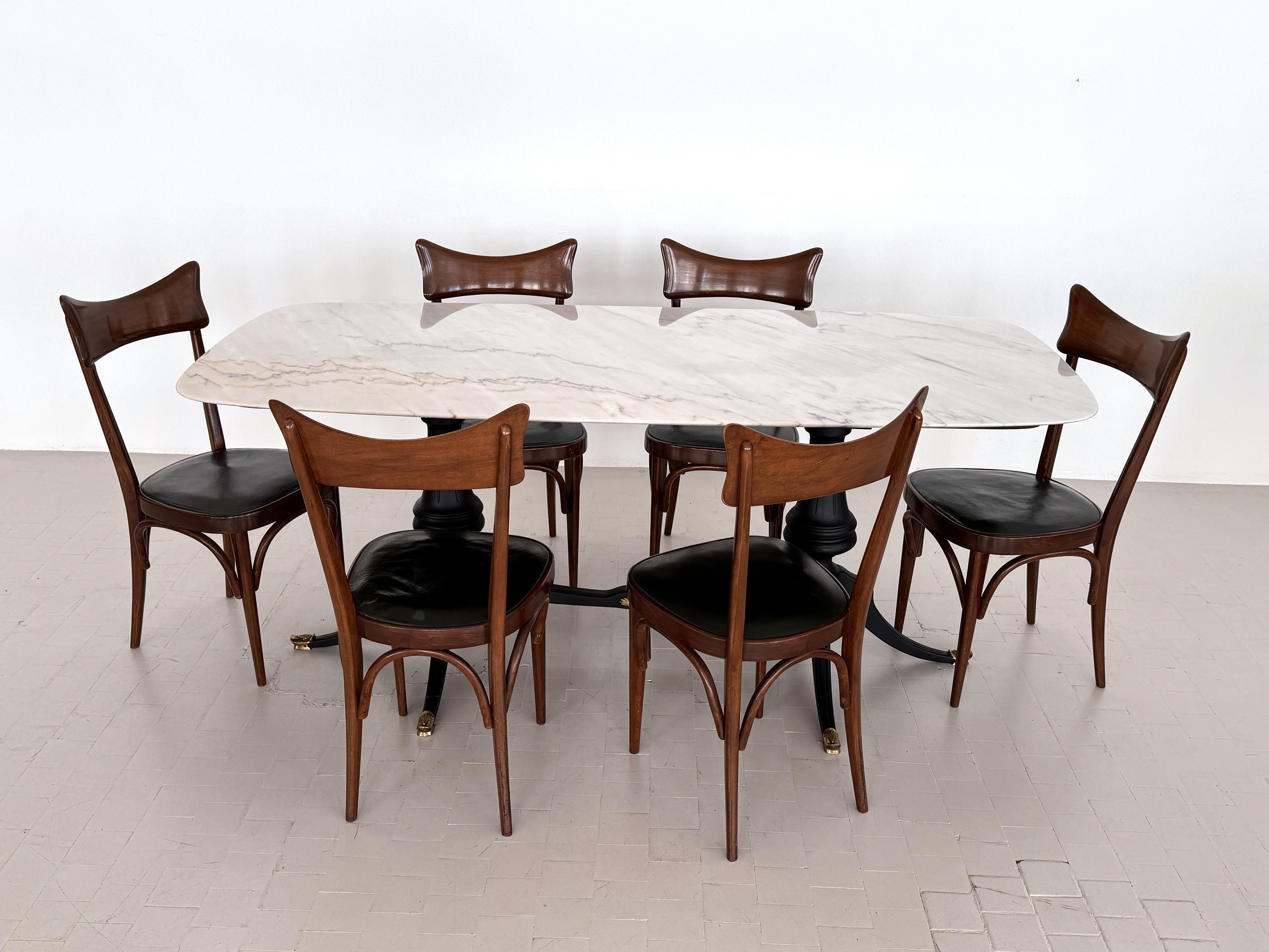 Italian Midcentury Sculptural Dining Room Table with Marble Top, 1950s

Beautiful dining table, made in Italy in the 1950s.
The dining table has an impressive base made of beech wood, which has been stained black and painted. 
The foot tips and a