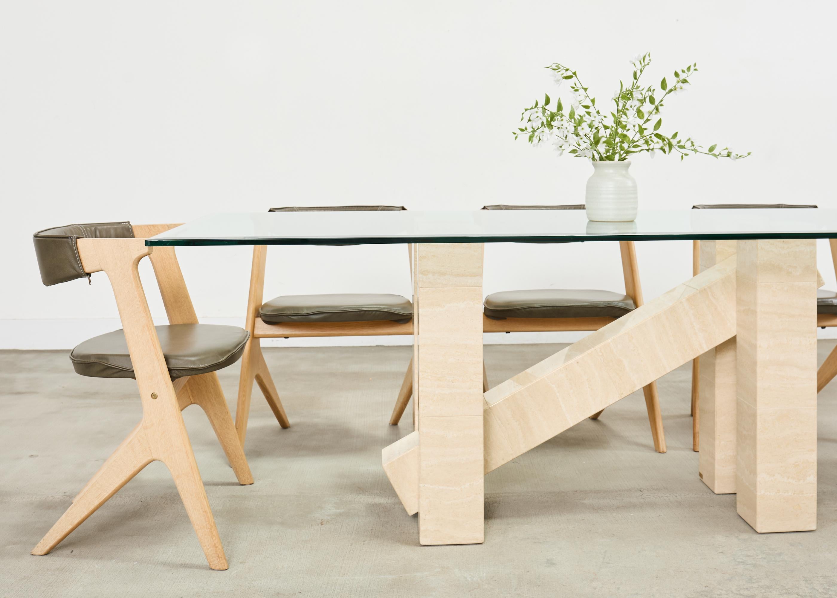 Table de salle �à manger italienne architecturale et moderne du milieu du siècle, fabriquée à partir d'épais poteaux de travertin dans un style tréteaux au design sculptural. La table se compose de cinq poteaux géométriques de quatre pieds reliés par