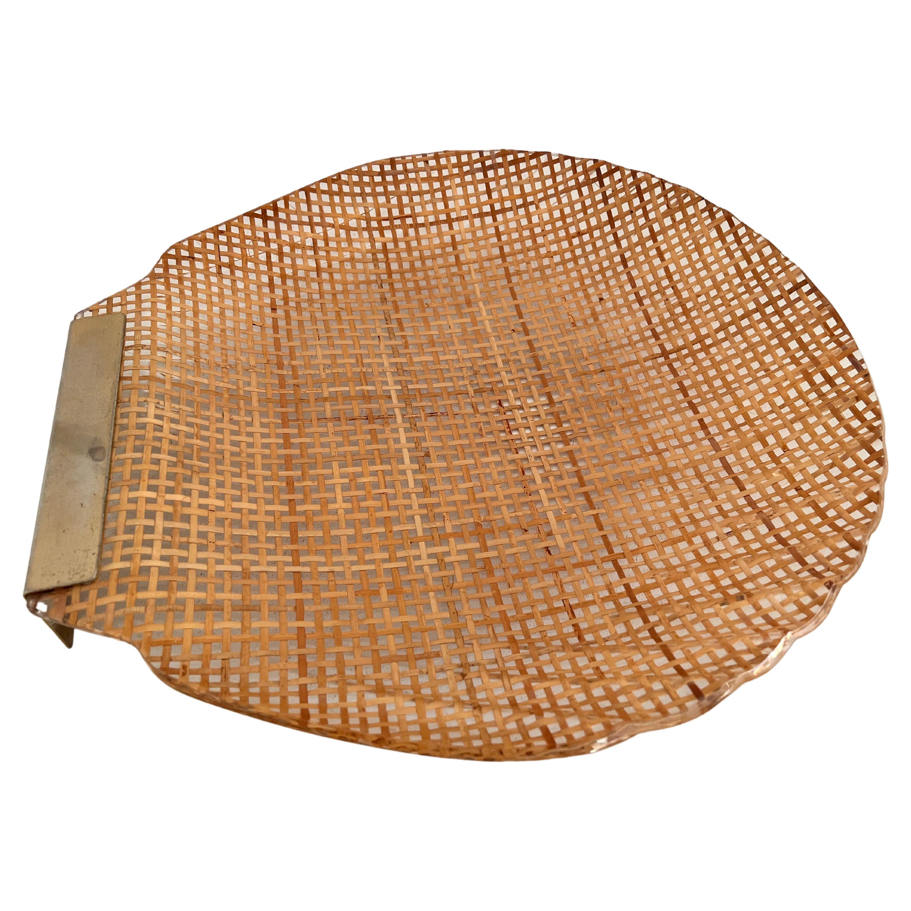 Gorgeous serving tray, in the shape of a shell, made of lucite, rattan and brass.
Made in Italy in the 1970s. 
Braided rattan is cast within the Lucite acrylic material. Beautiful workmanship.
The brass part is kept in original vintage version,