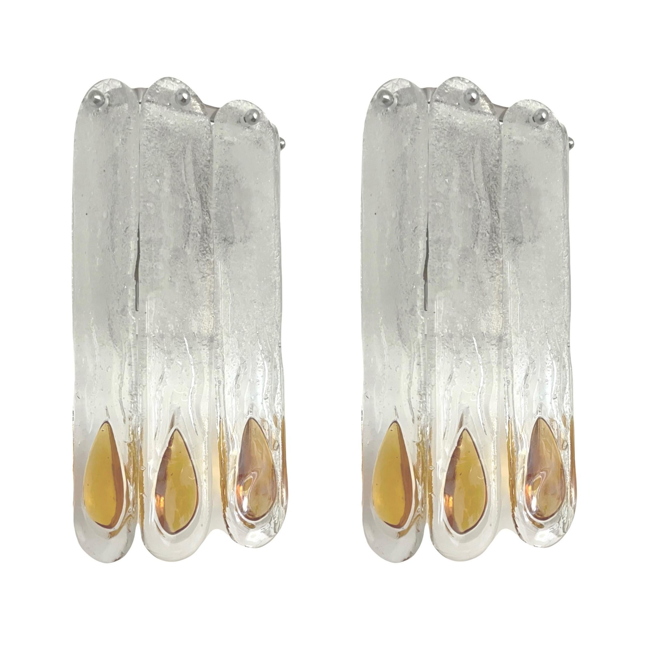 Stunning and beauty Set of Three Italian Amber Clear Murano glass Wall Sconces. These fixtures were designed and manufactured during the 1970s in Italy by Mazzega.
Mazzega lie in the noble Venetian glassworking tradition; the firm was founded Angelo