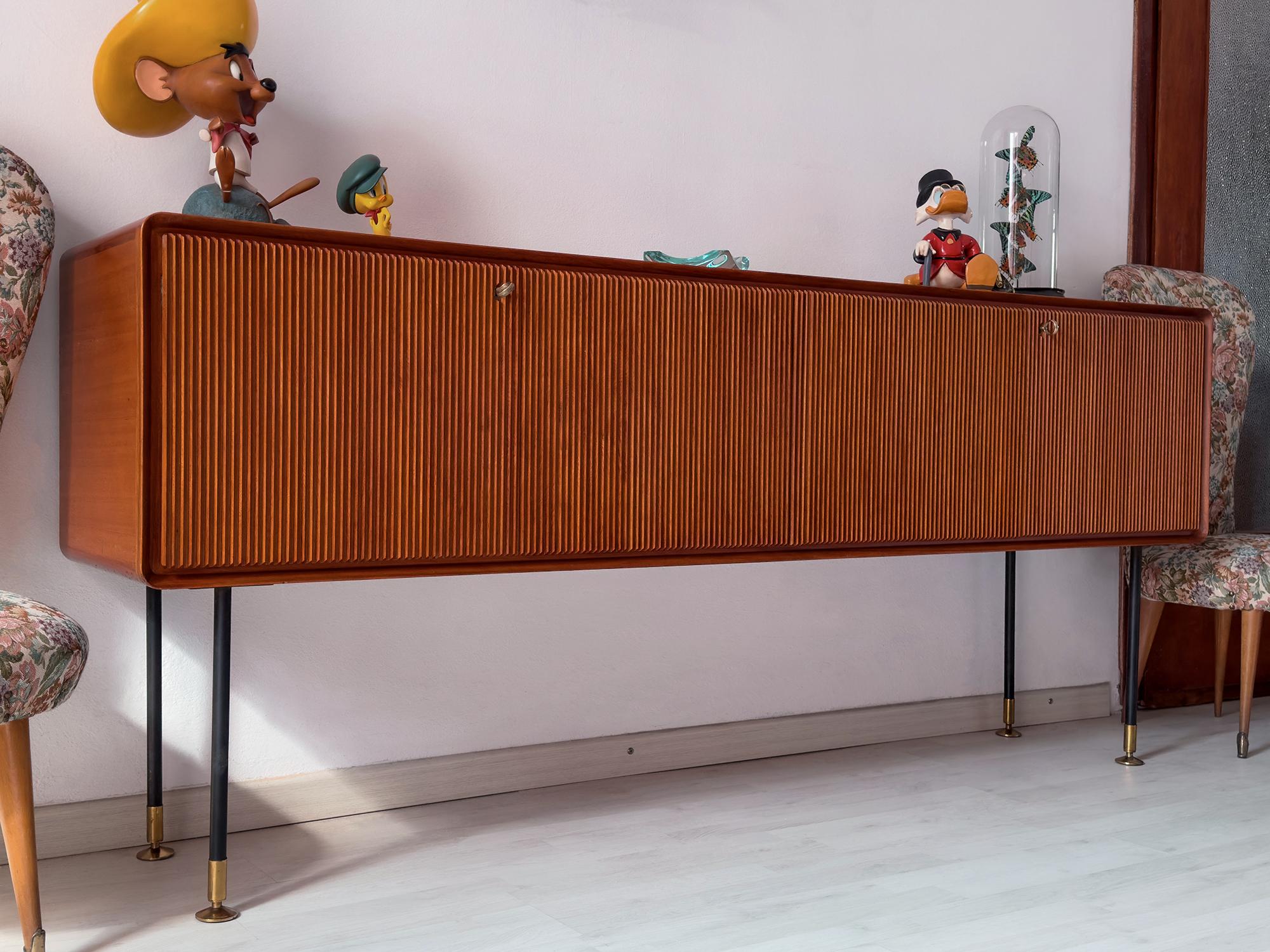This magnificent Italian Sideboard in teak wood is a stunning example of the exceptional craftsmanship produced by the Consorzio Esposizione Mobili Cantù in the 1950s.
Founded in 1949, the consortium aimed to bring together the best of Canturina