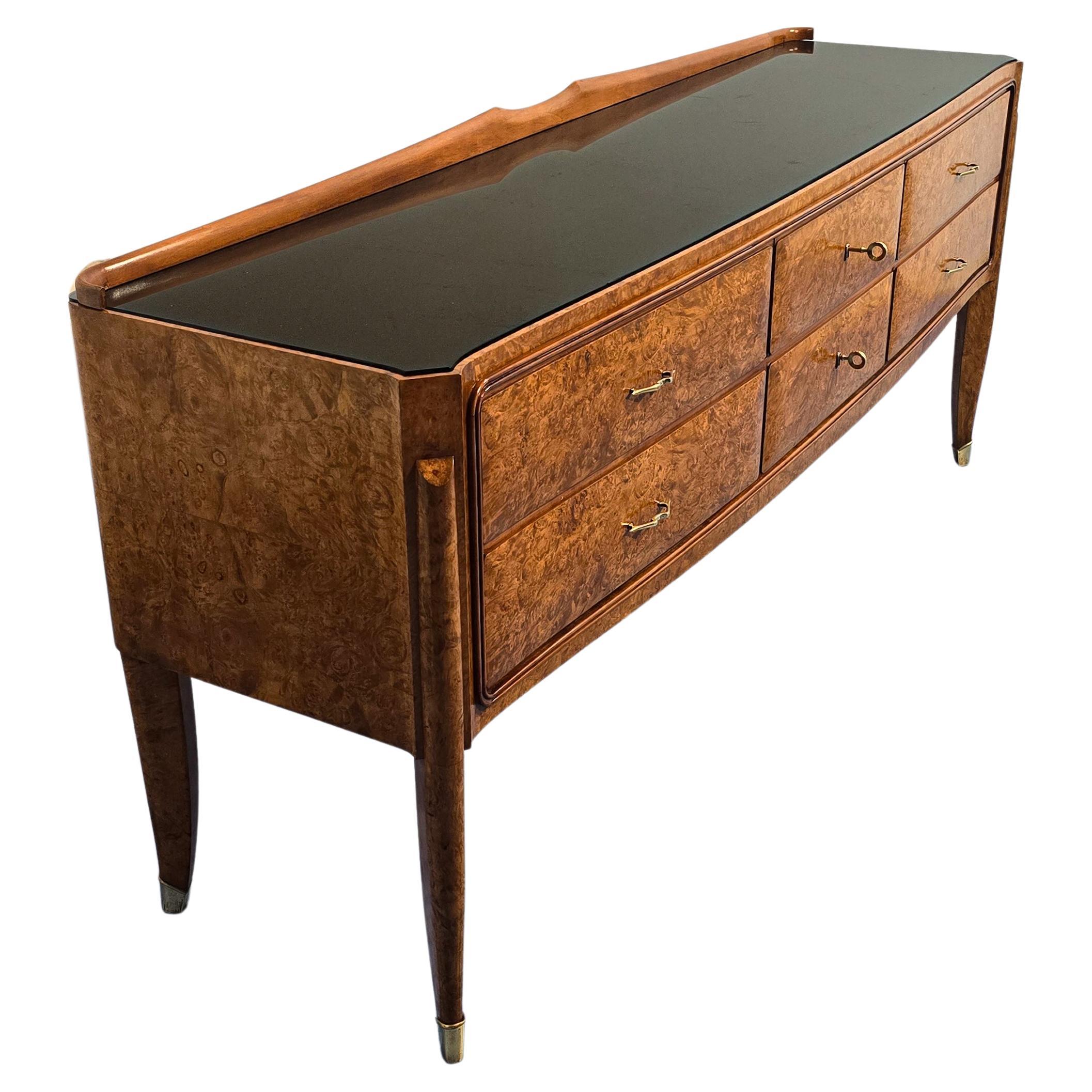 Buffet ou commode italienne du milieu du siècle dernier, attribuée à Paolo Buffa, années 1950, en bois précieux d'Amboine avec des tons chauds de patine, la façade avec une ligne légèrement incurvée se caractérise par la présence de quatre tiroirs