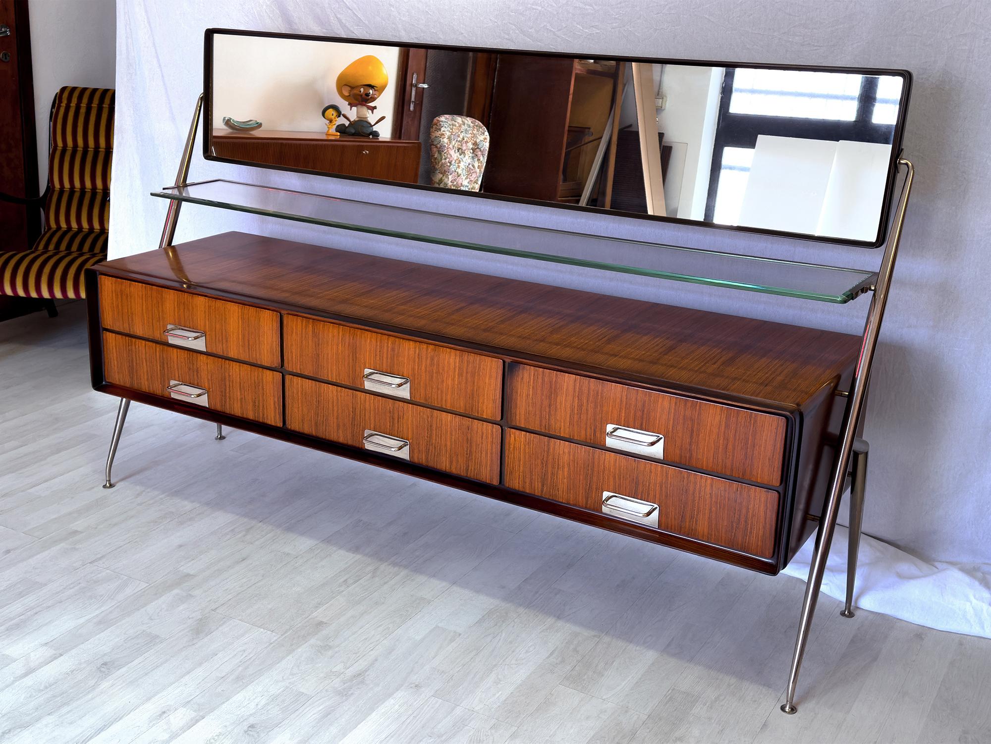 Stunning Italian sideboard and/or dresser, very well designed by Silvio Cavatorta in 1950s.
The cabinet is made of gorgeous teak wood and equipped with six drawers finished with brass chromed details.
It’s surmounted by a fixed shelf in thick art