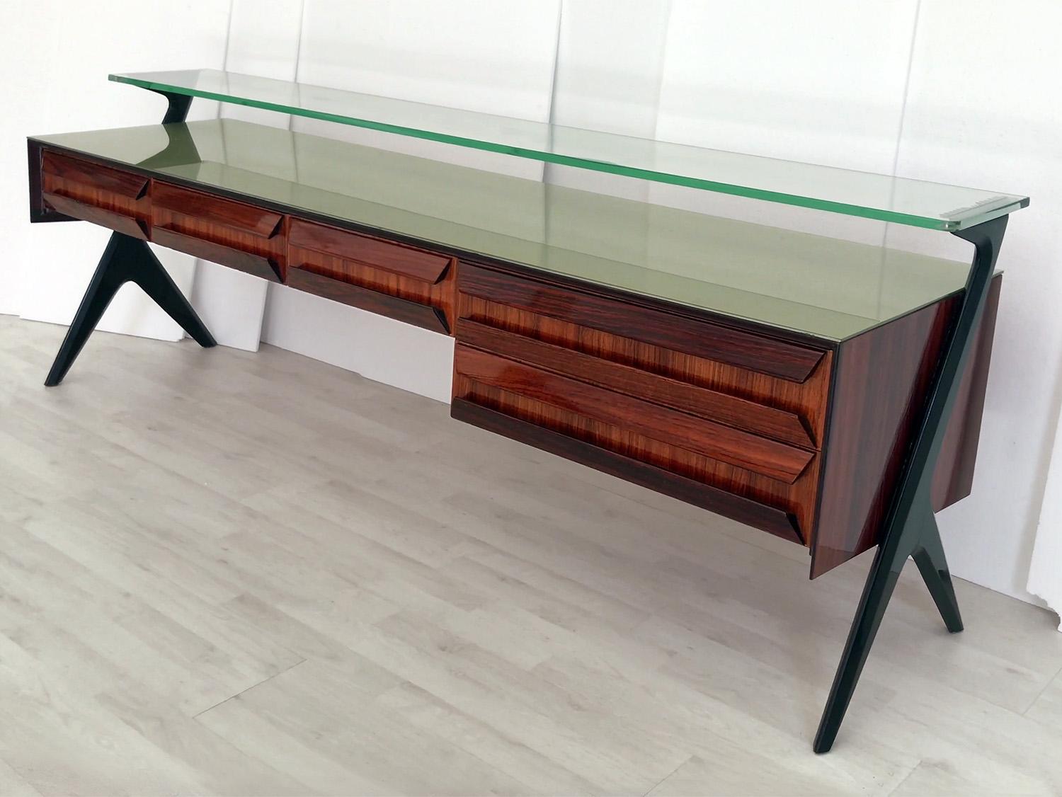 Splendida credenza e/o cassettiera Vanity disegnata da Vittorio Dassi e Plinio Dassi negli anni Cinquanta.
La sua unicità estetica è data dall'originale design scultoreo dei cassetti e dei supporti laterali, oltre che dal piano in vetro verde