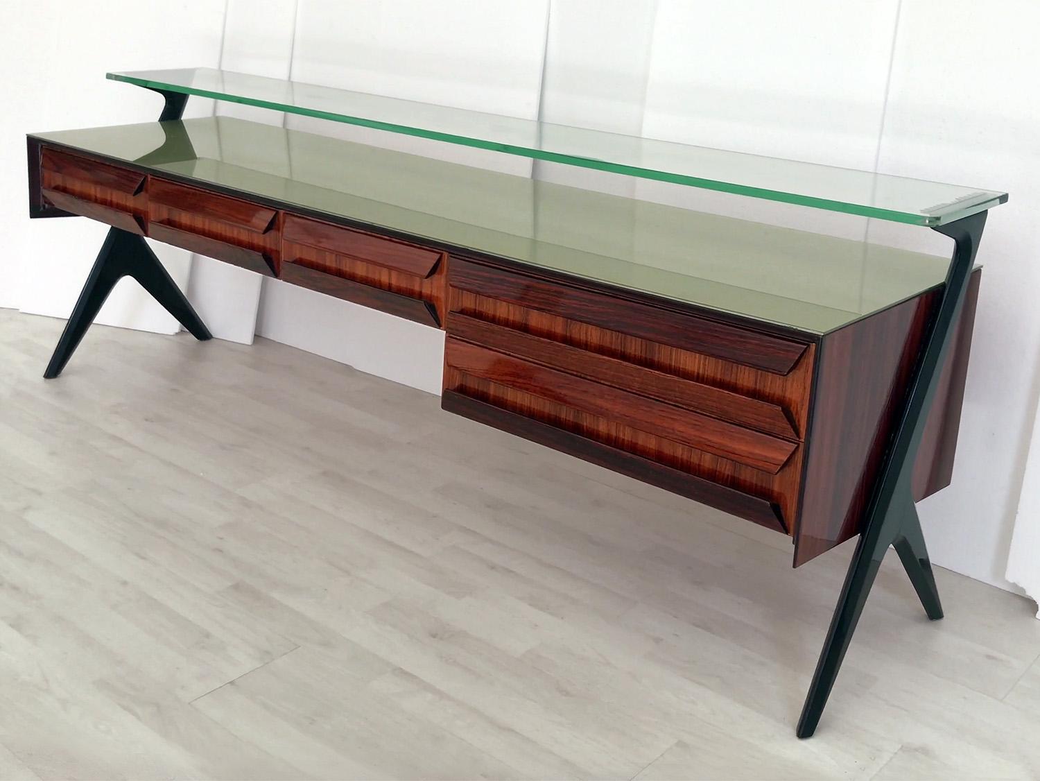 Stunning Sideboard and/or Vanity dresser designed by Vittorio & Plinio Dassi in the 1950s.
Its aesthetic uniqueness is given by the original sculptural shape design of the drawers and lateral supports, in addition with the top green glass