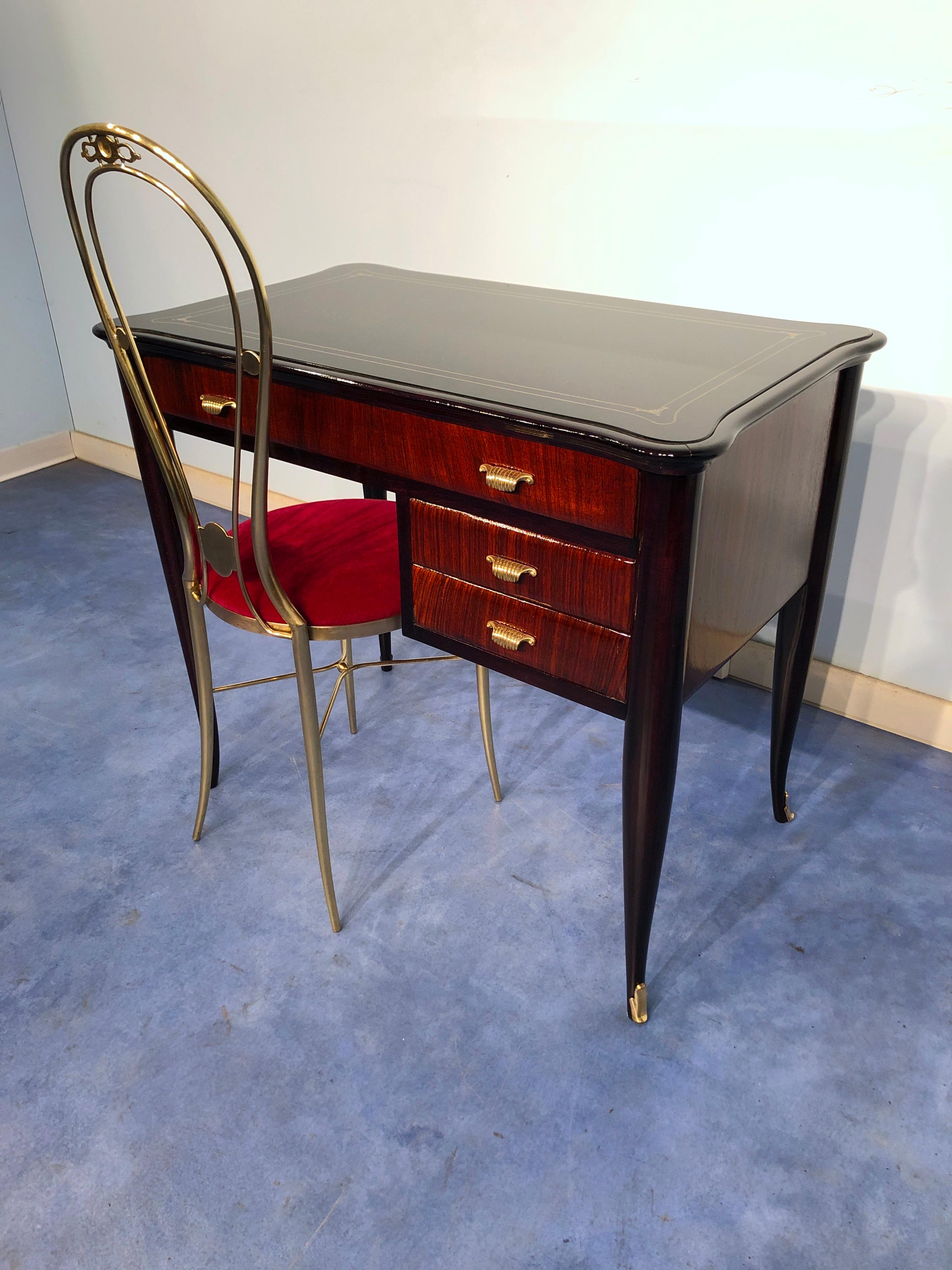 Cute and stylish Italian midcentury modern desk, with a graceful chair, attributed to Paolo Buffa. 
This teakwood desk it is a splendid example of the Italian class design of 1950.
Black glass tabletop with gold decorations, shaped on the sides,